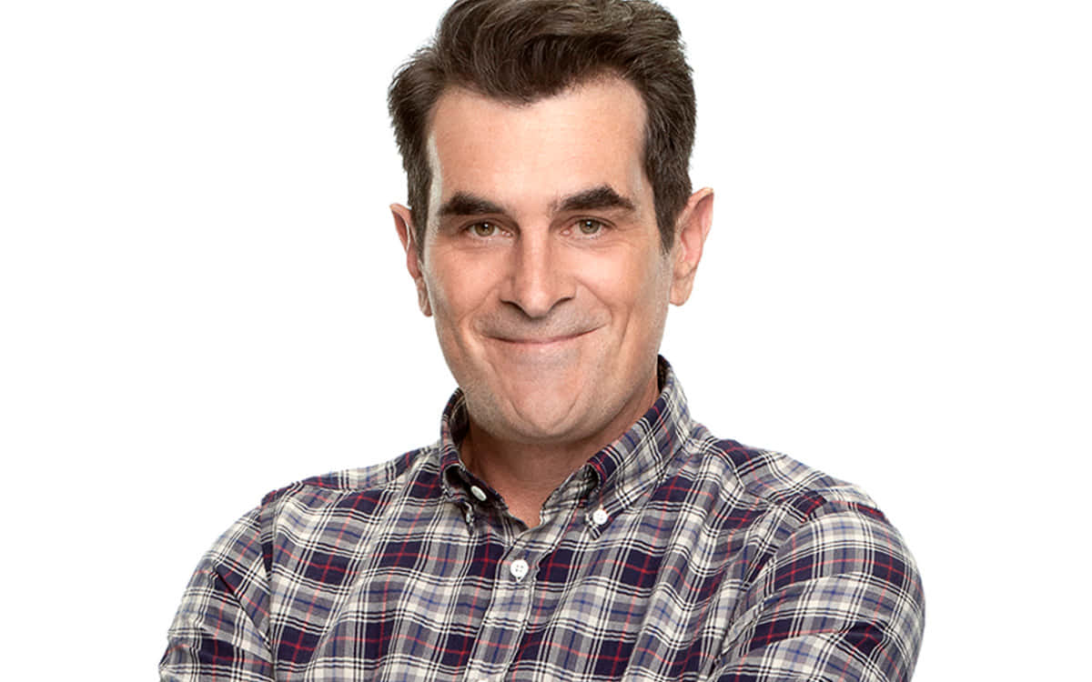 Ty Burrell 桌布 壁紙 — 一名穿著格子襯衫的男子在純白背景前溫暖地微笑。