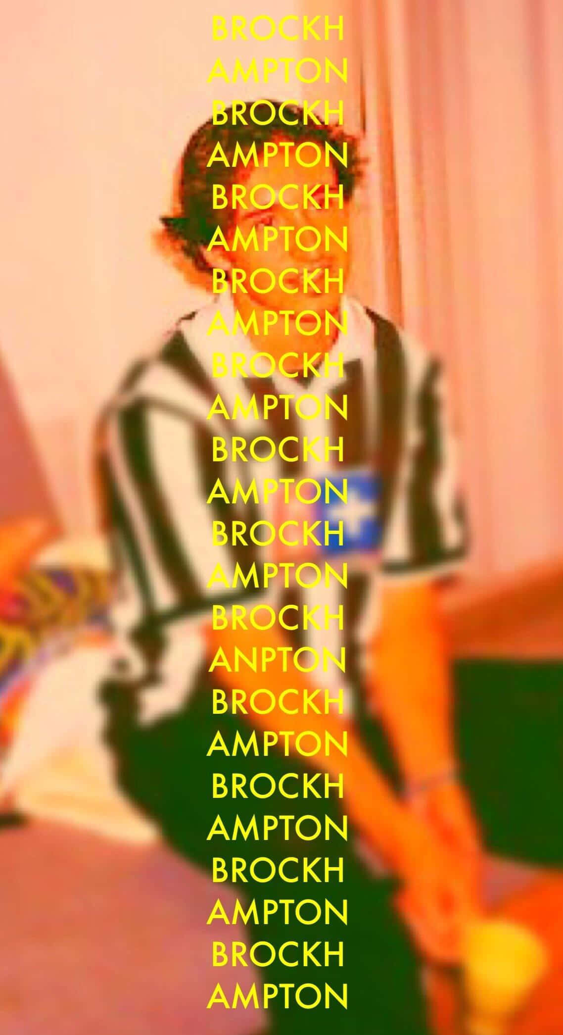 Brockhampton 桌布 壁紙 — 一名穿著條紋襯衫的人站在溫暖粉紅色背景上，粗體黃色垂直文字「BROCKH AMPTON」的後面。