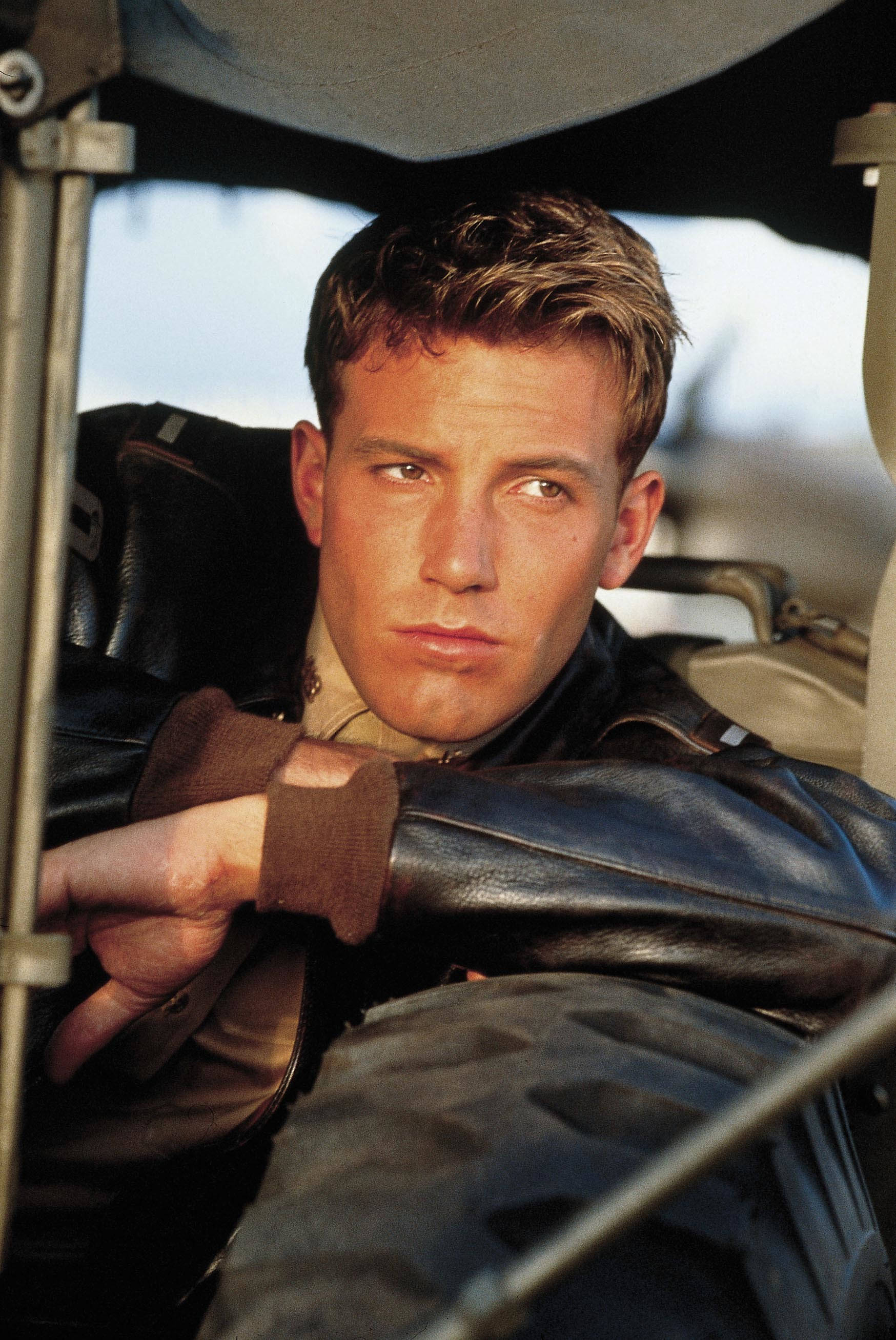 Ben Affleck 桌布 壁紙 — 一名穿著皮革飛行外套的年輕男子在駕駛艙內專注地向前傾。
