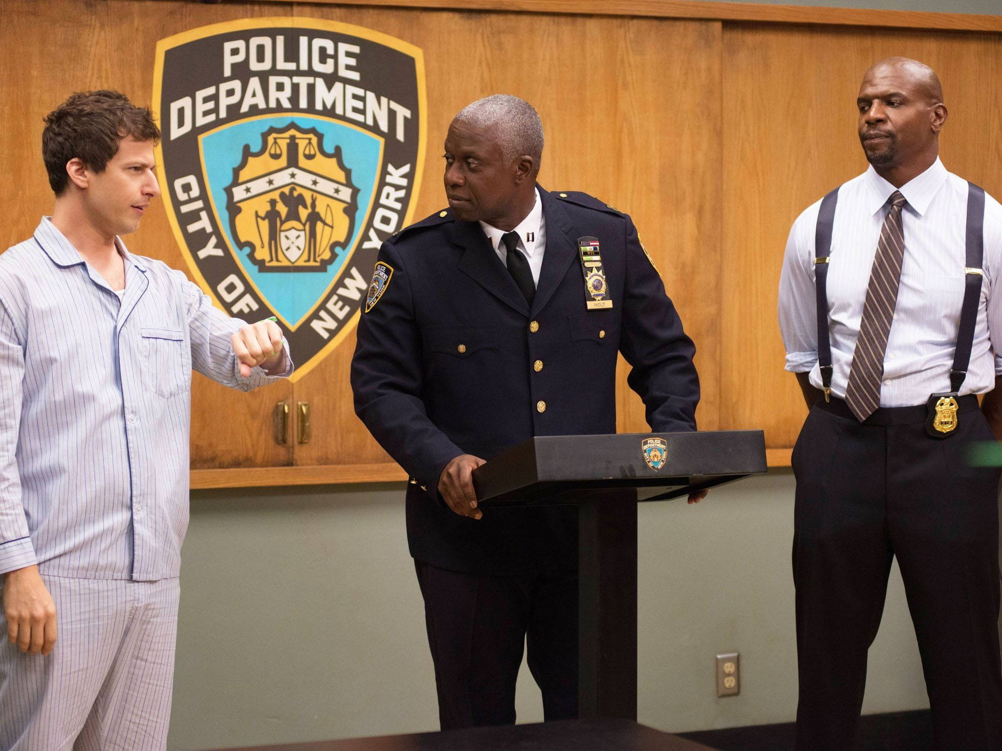 Brooklyn 桌布 壁紙 — 一名穿著睡衣的男子在講台上與一名警察局長碰拳，身後有NYPD徽章。