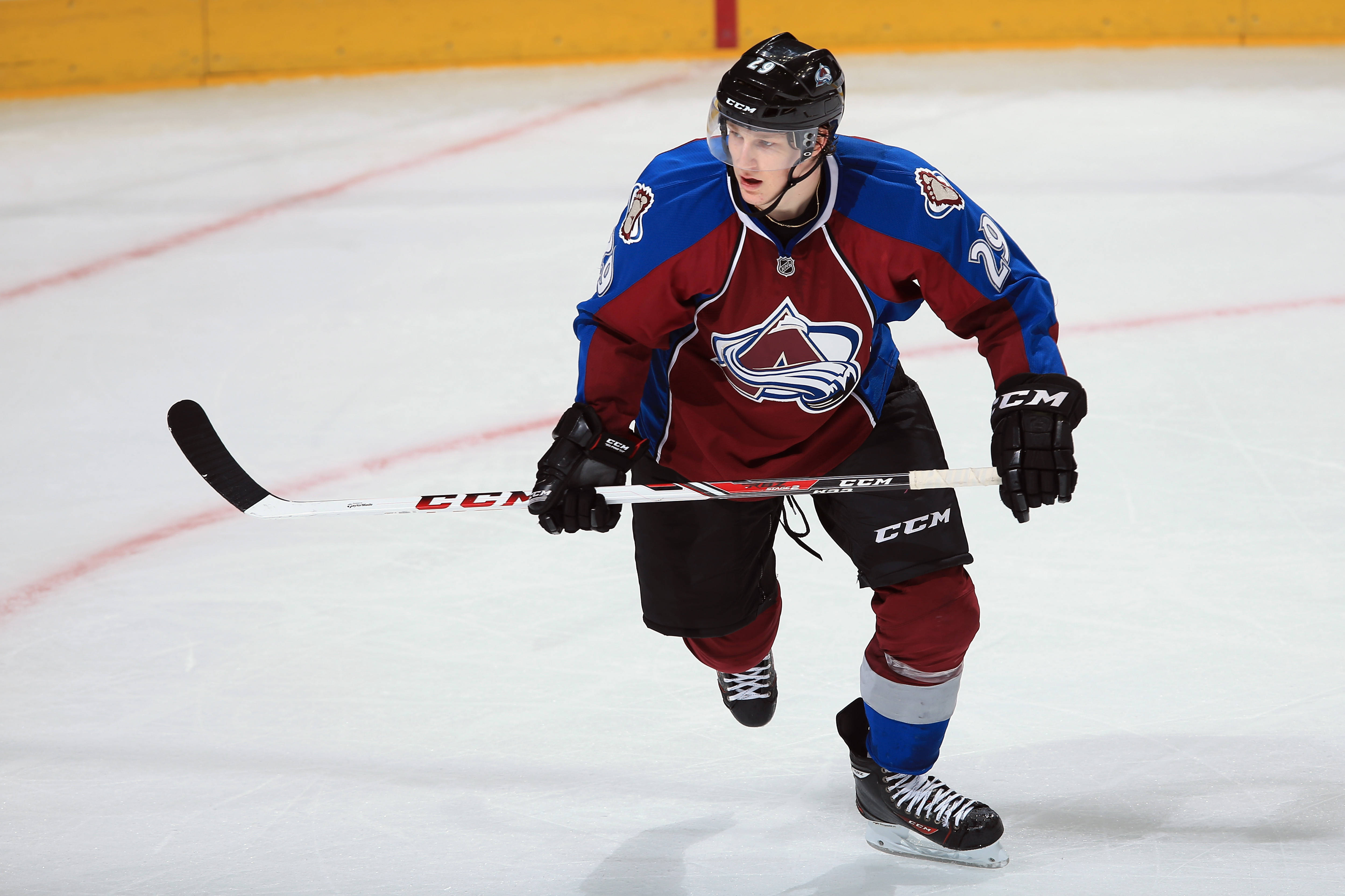 運動 桌布 壁紙 — 一名穿著科羅拉多雪崩隊球衣的冰球運動員在冰場上專注地激烈滑行。