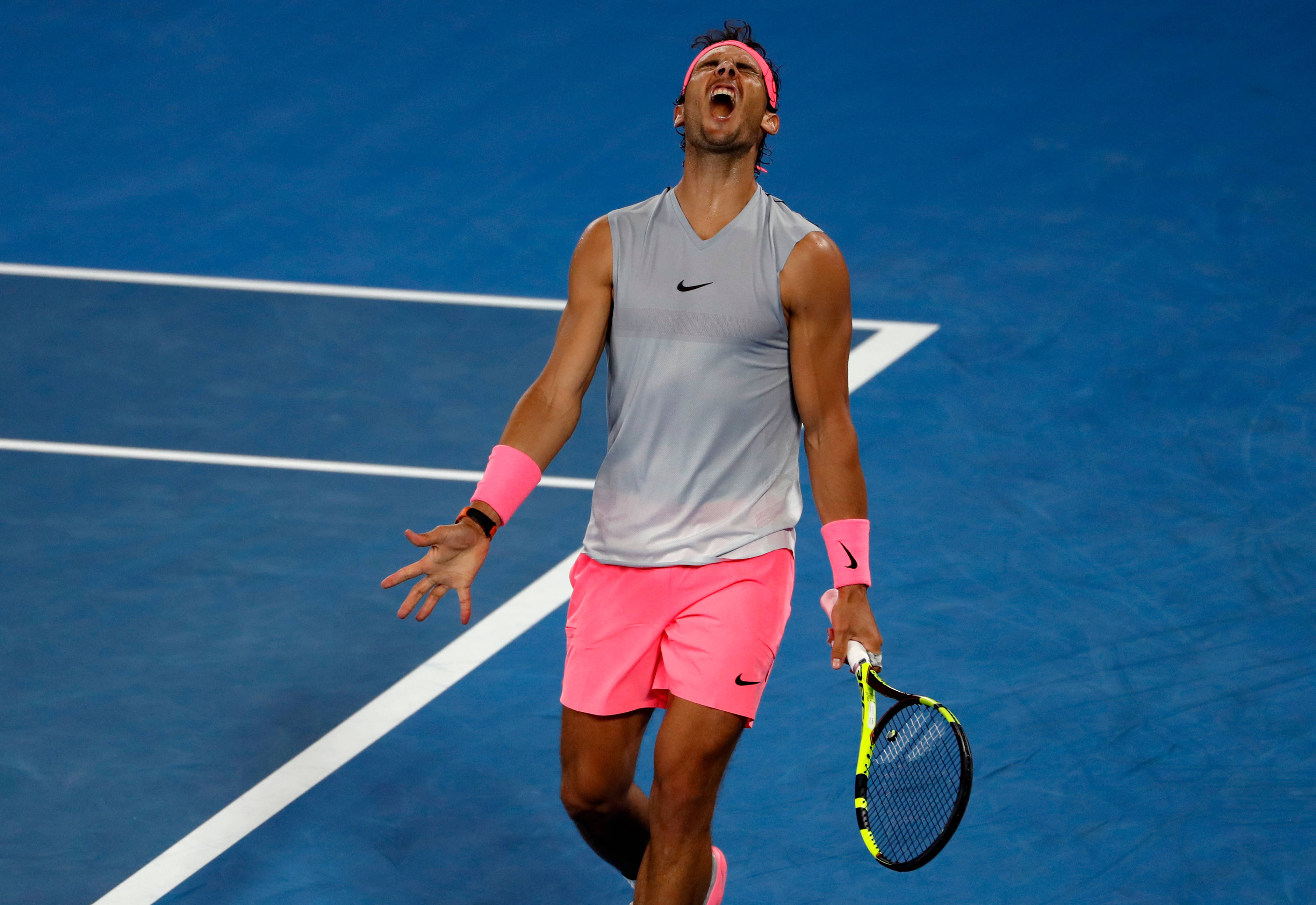 Tennis 桌布 壁紙 — 一名穿著粉紅色短褲和頭帶的網球選手在藍色硬地球場上高舉球拍，勝利地吶喊。