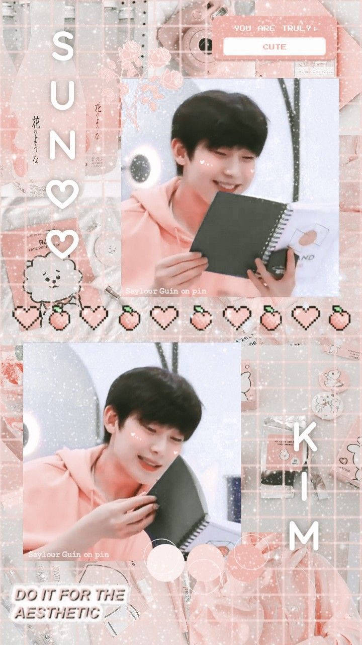 Enhypen Aesthetic 桌布 壁紙 — 一名穿著粉紅色連帽衫的年輕男子微笑著，在帶有心形和文字疊加的粉彩粉紅色拼貼背景前拿著筆記本。