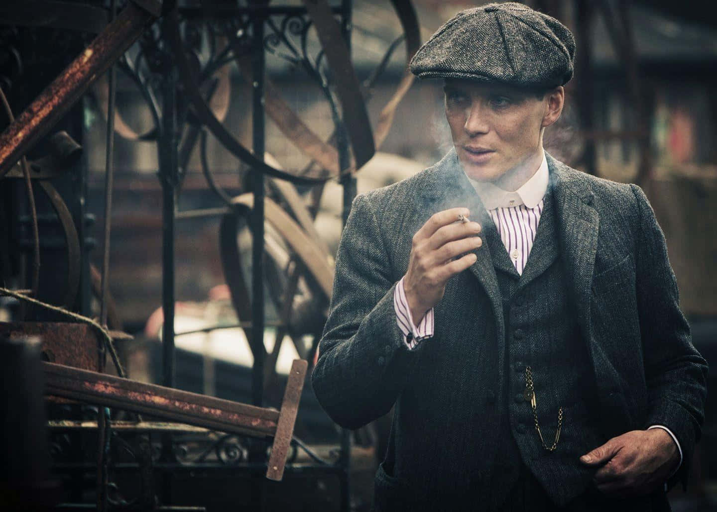 穿著復古西裝的男子在工業環境中抽煙 — Peaky Blinders 壁紙