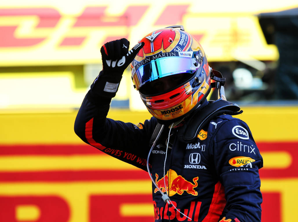 F1車手穿著賽車服和頭盔慶祝勝利。 — 紅牛F1 壁紙