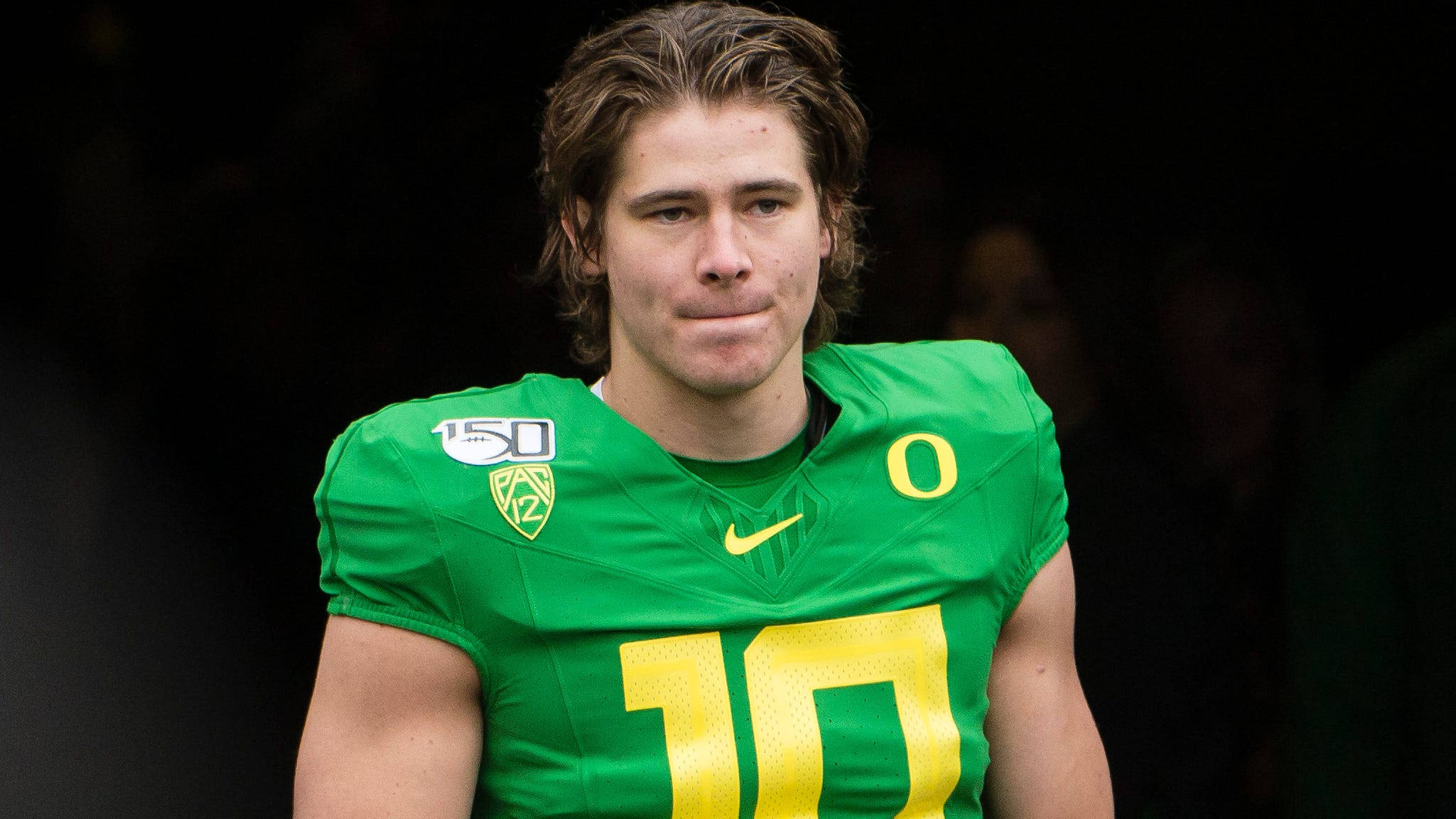 Herbert 桌布 壁紙 — 一名穿著綠色球衣、黃色10號和Oregon標誌的美式足球員特寫，直視鏡頭。