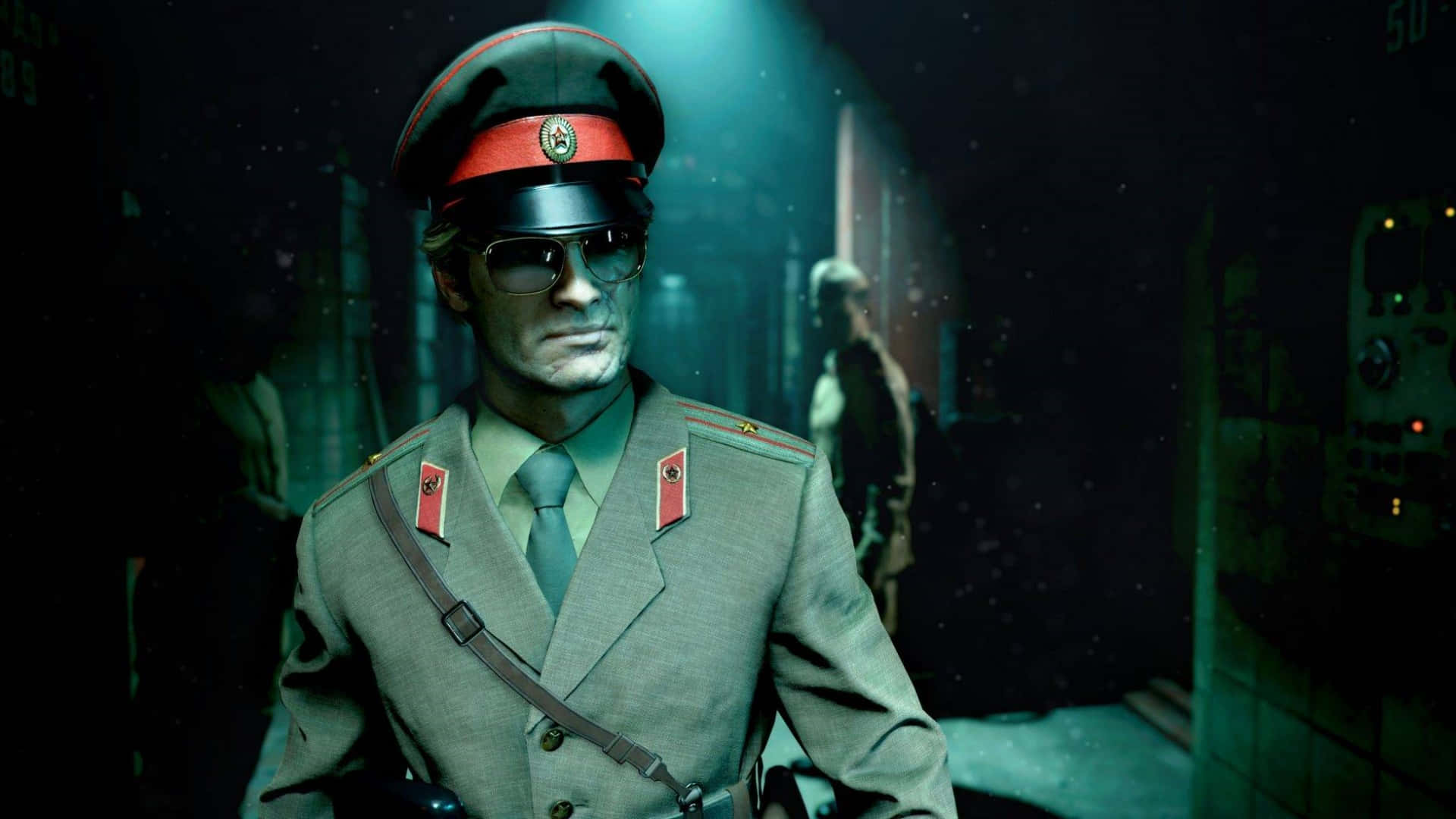 1920x1080 Call Of Duty Black Ops Cold War 桌布 壁紙 — 一名穿著蘇聯風格制服和太陽眼鏡的嚴肅士兵，站在光線昏暗、粗糙的走廊中，帶有綠色照明和漂浮粒子。