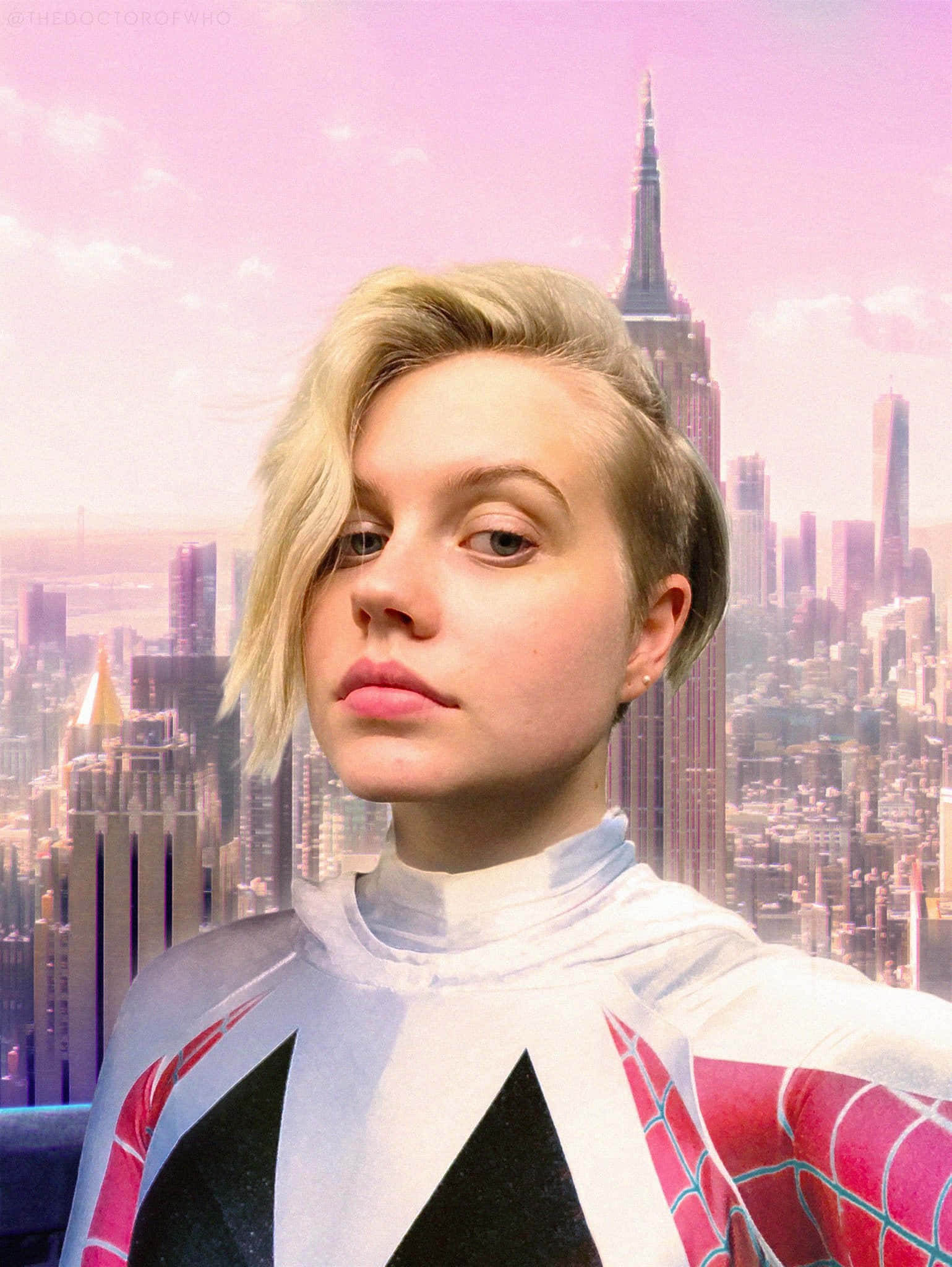 Betty Brant 桌布 壁紙 — 一名穿著蜘蛛人服裝的人士在粉紅色調的紐約市天際線（包括帝國大廈）前擺姿勢。