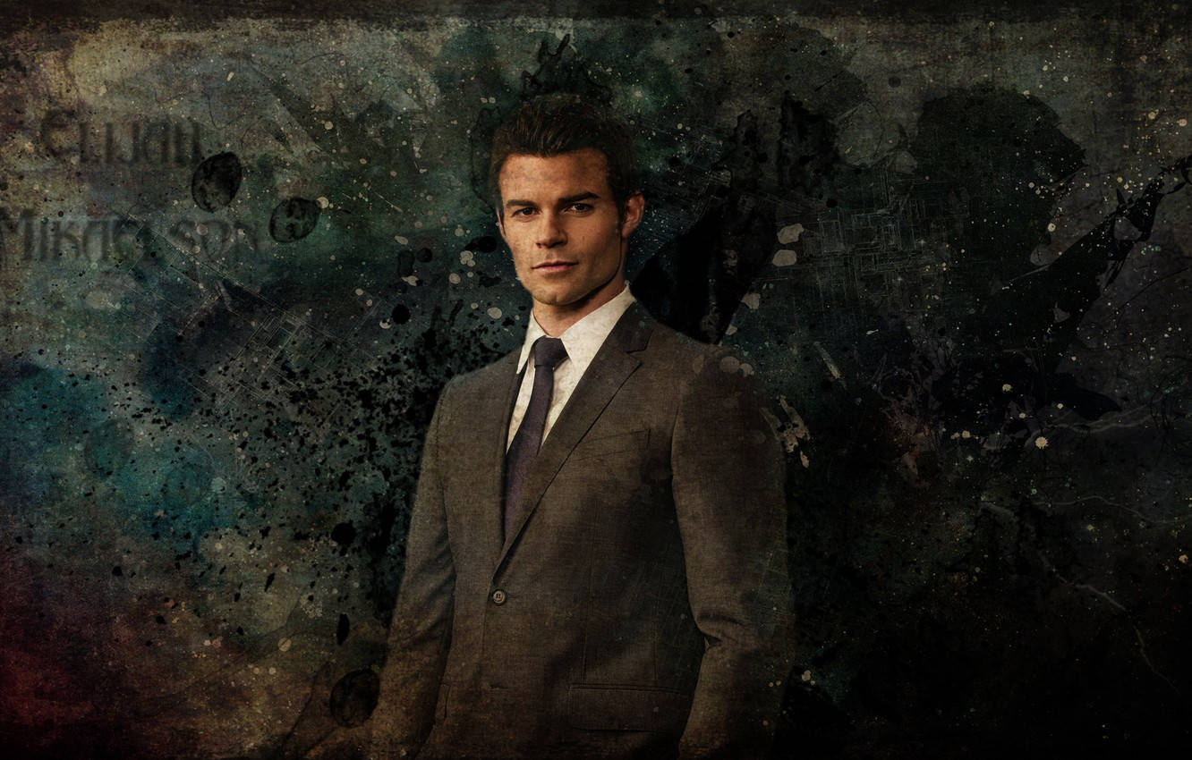 elijah mikaelson 桌布 壁紙 — 一名穿著西裝的男子站在帶有飛濺顏料和模糊文字的深色紋理背景前。