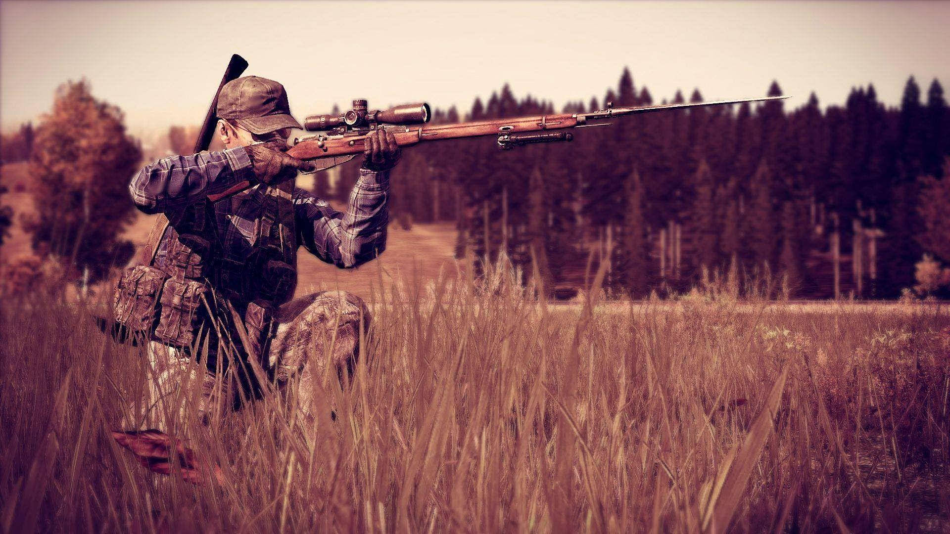 Dayz Desktop 桌布 壁紙 — 一名穿著迷彩裝備的獵人蹲在高草叢中，用帶瞄準鏡的步槍瞄準遠處的森林。