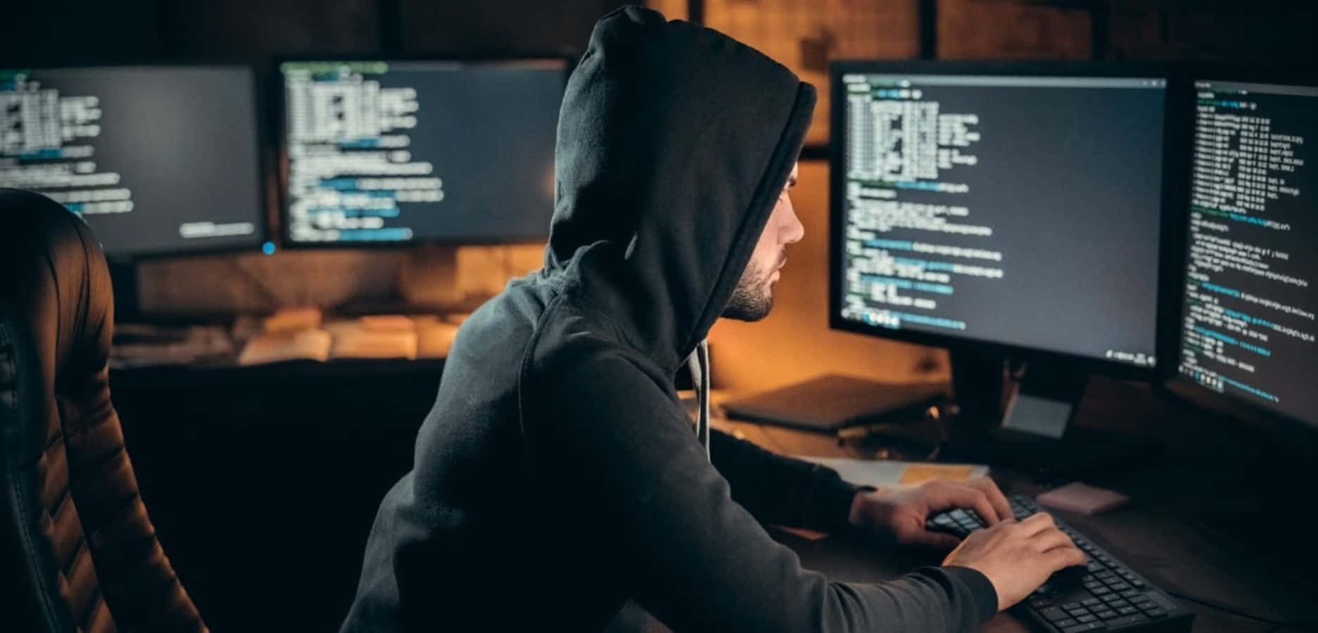 一名穿著連帽衫的男子正在操作電腦 壁紙