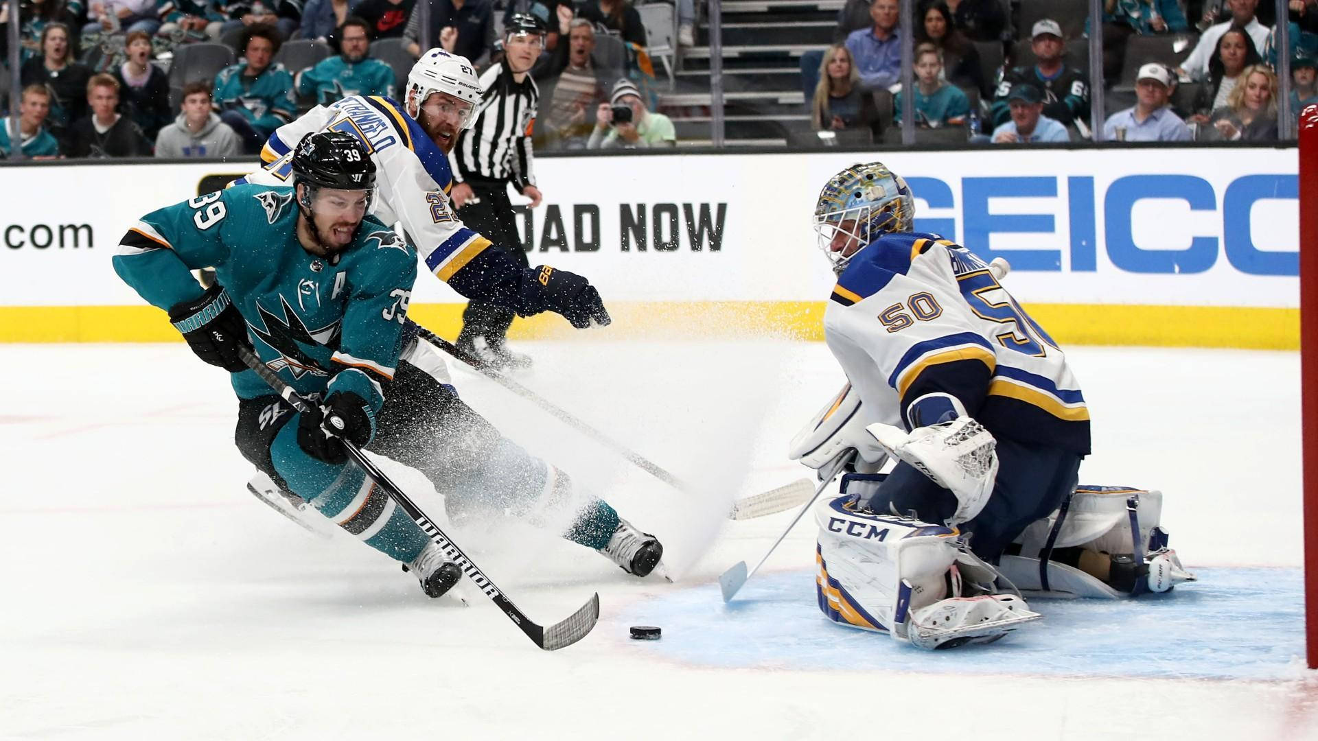 hockey 桌布 壁紙 — 一名穿著青綠色的曲棍球選手在冰上滑向球門，而守門員飛身撲救阻擋射門。