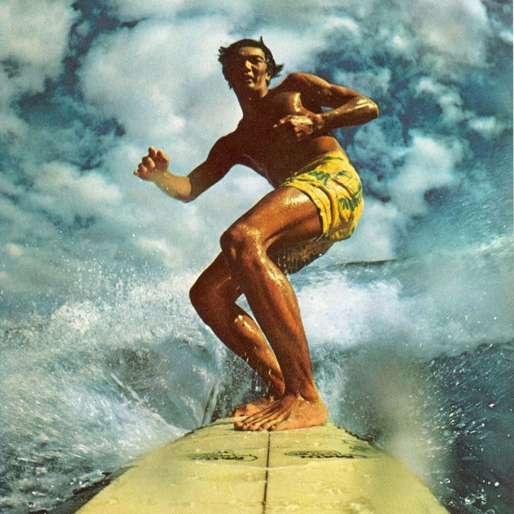 surfing 桌布 壁紙 — 一名穿著黃色泳褲的衝浪者在多雲的天空下乘著強勁的海浪，周圍水花四濺。