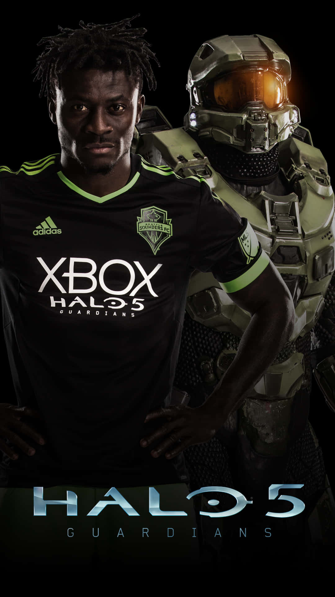足球 桌布 壁紙 — 一名穿著黑色Xbox Halo 5球衣的足球員站在發光橙色面罩的Halo 5 Spartan旁邊，背景為深色。