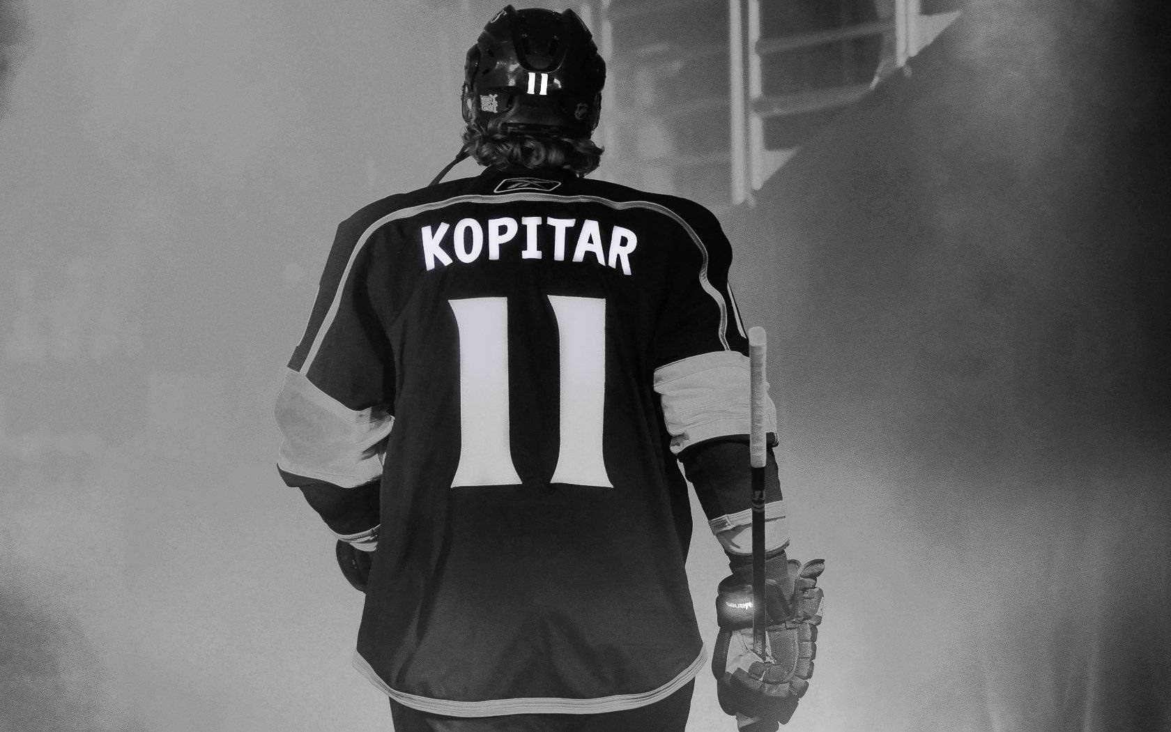 Athlete 桌布 壁紙 — 一名穿著黑色球衣、上面有「KOPITAR」和11號的冰球運動員，手持球棍穿過煙霧走開。