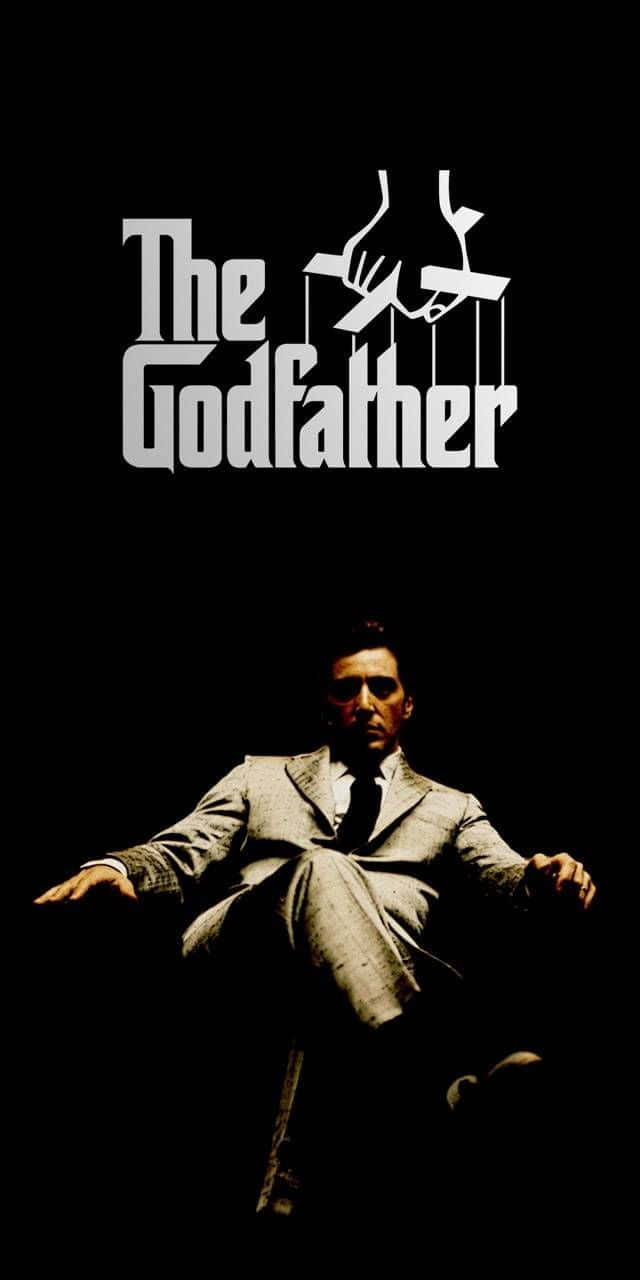 The Godfather 桌布 壁紙 — 一名穿西裝的男子坐在陰影中，上方有『教父』標題，雙手像木偶線般舉起。