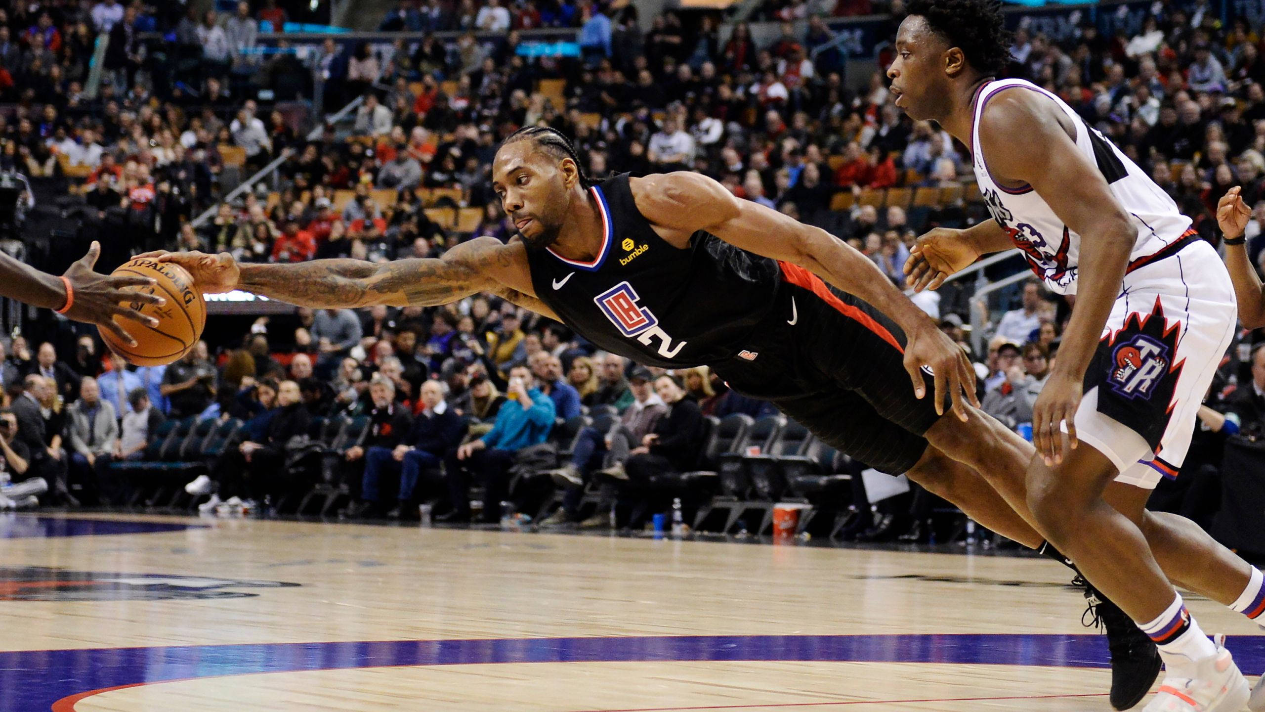 Kawhi 桌布 壁紙 — 一名籃球運動員低身撲球以確保控球，而防守球員在激烈的比賽中逼近。