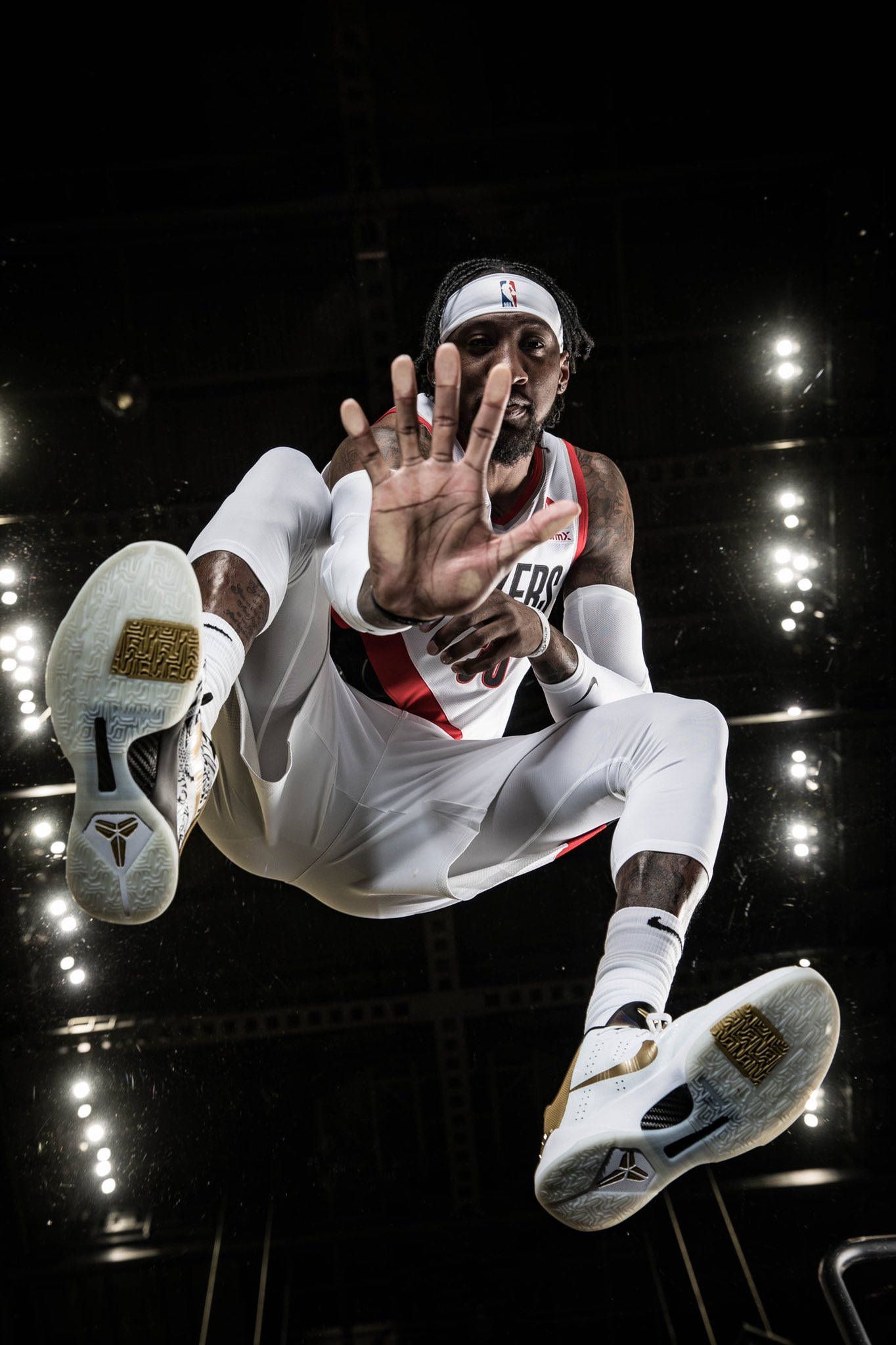 robert covington 桌布 壁紙 — 一名籃球運動員在半空中，身穿白色和紅色球衣，金色運動鞋，背景是黑暗的場館燈光。