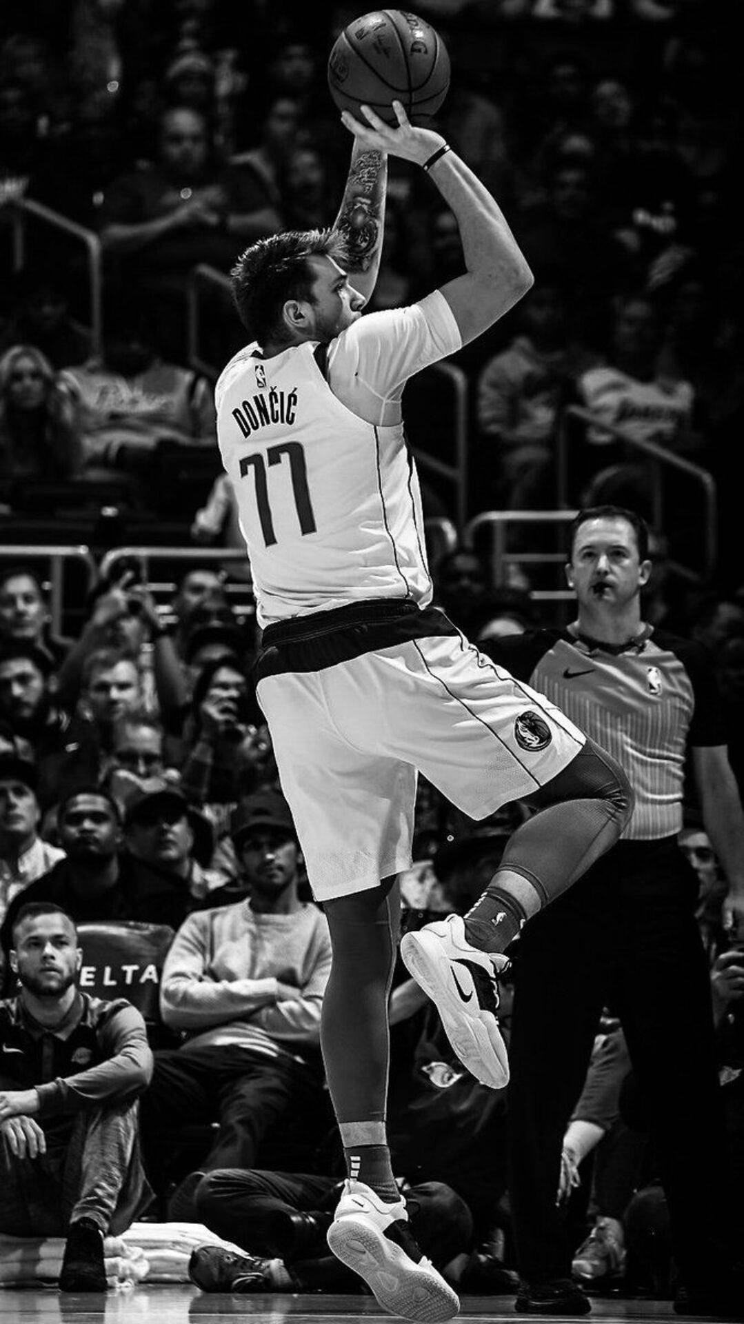 Luka 桌布 壁紙 — 一名籃球運動員在半空中投籃，背景有模糊的人群和裁判。