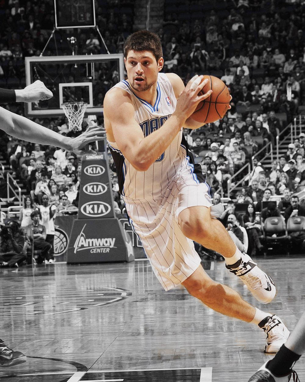 NBA 桌布 壁紙 — 一名籃球運動員在比賽中專注地帶球上籃，防守球員伸手攔截，場面緊張刺激。