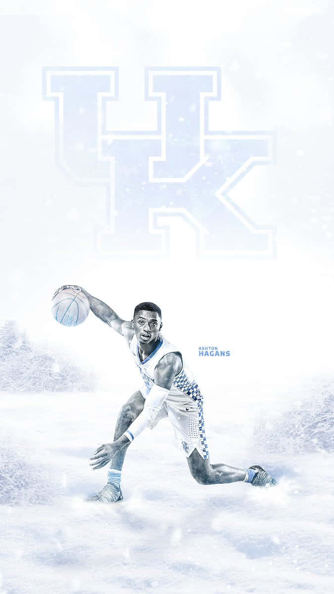 Kentucky Basketball 桌布 壁紙 — 一名籃球運動員在雪地景觀中運球，一個大型英國標誌漂浮在他上方。