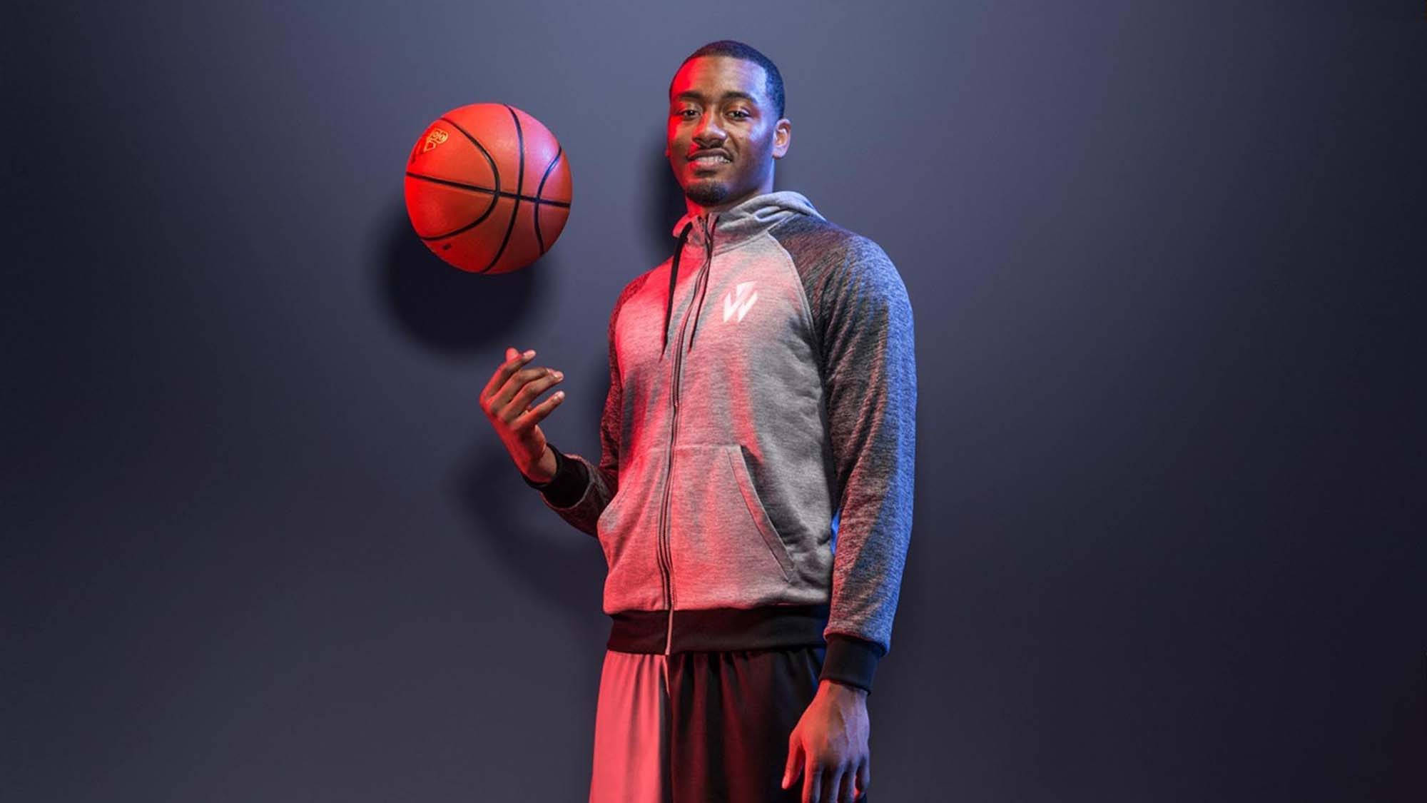 John Wall 桌布 壁紙 — 一名籃球運動員在黑暗的攝影棚背景下，以戲劇性的紅光將紅色籃球平衡在手指上。