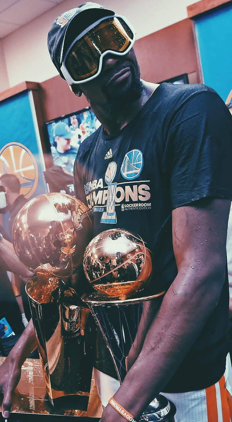 Trophy 桌布 壁紙 — 一名籃球運動員戴著超大護目鏡和冠軍T恤，在更衣室裡自豪地舉起兩座閃閃發光的NBA獎盃。