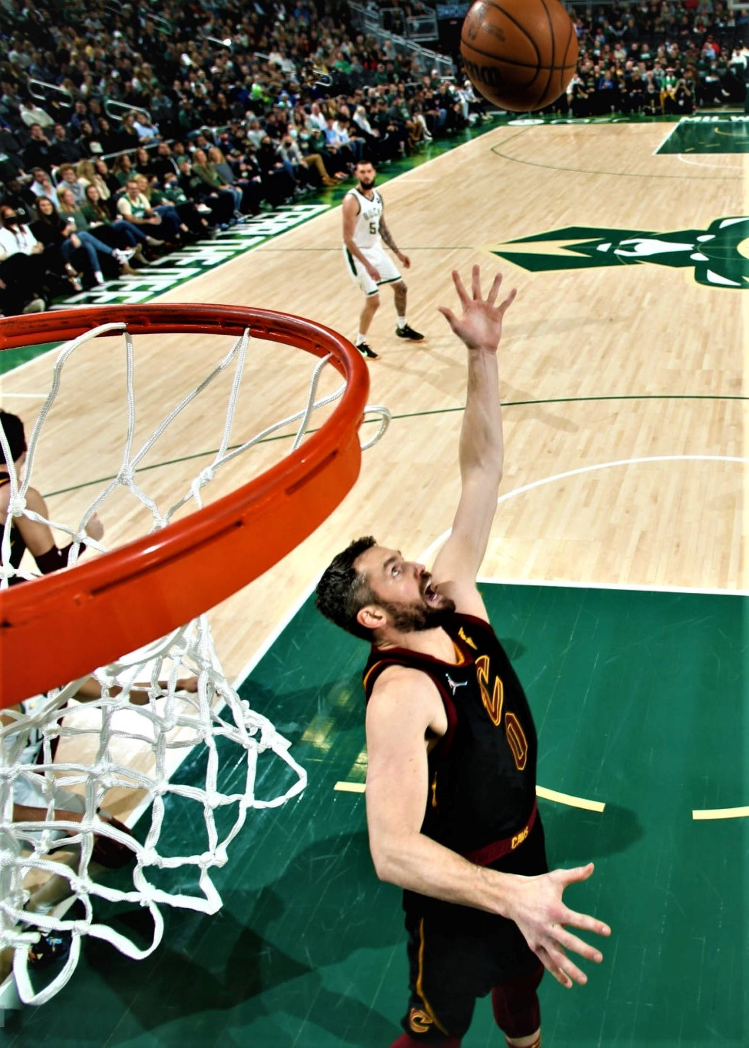 Kevin Love 桌布 壁紙 — 一名籃球運動員跳向籃框，球在空中，防守球員在球場上觀看。
