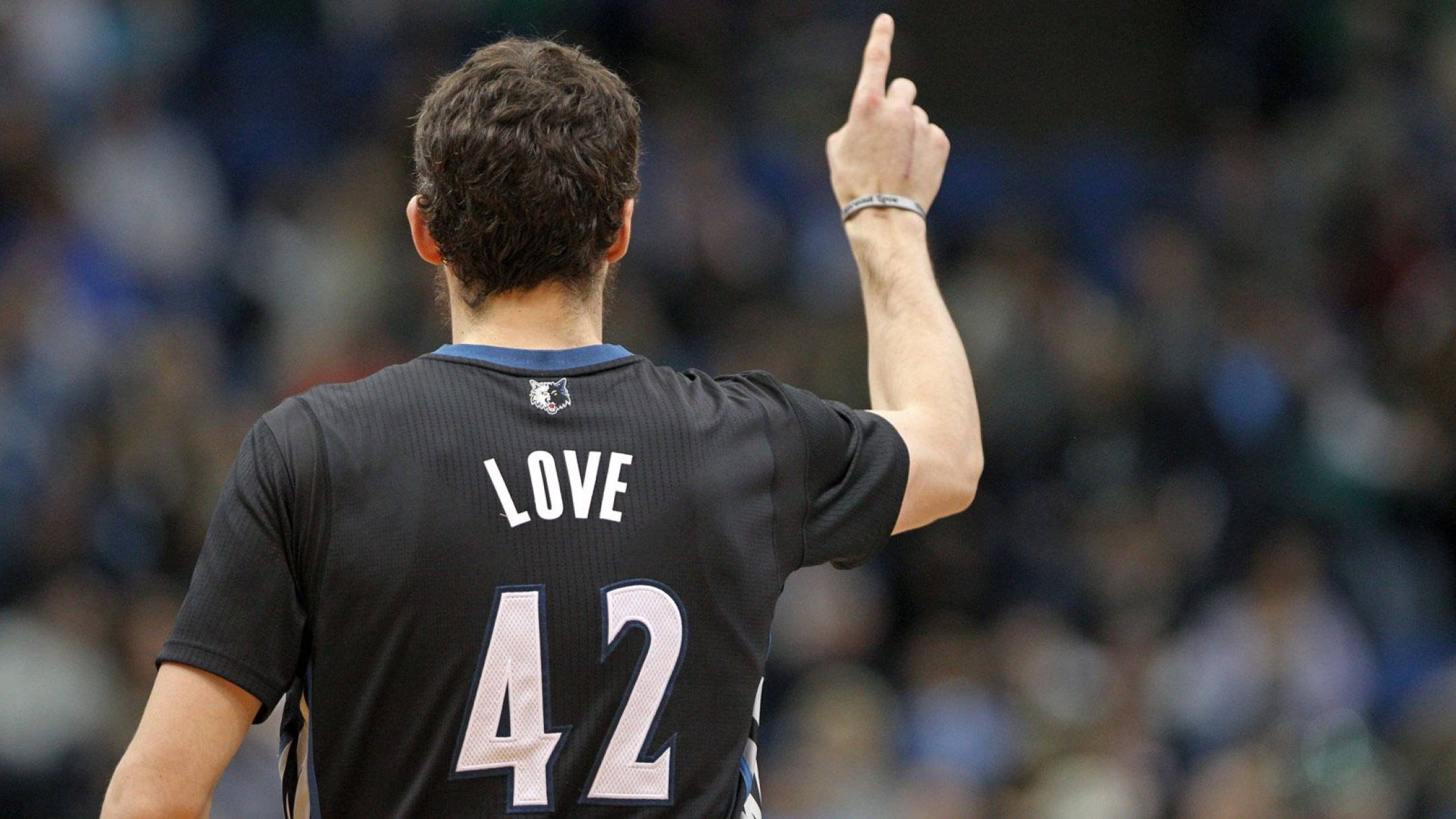 Kevin Love 桌布 壁紙 — 一名籃球運動員身穿黑色球衣，上面印有名字LOVE和號碼42，背對鏡頭用右手向上指。