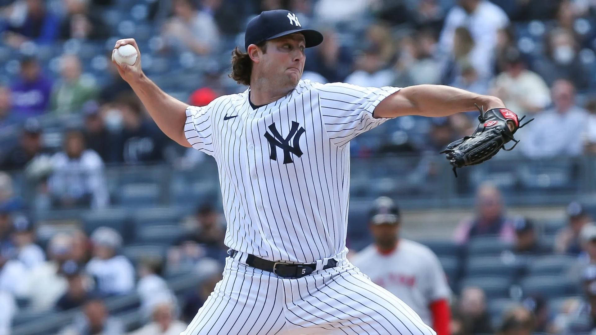 Gerrit Cole 桌布 壁紙 — 一名紐約洋基隊投手在日間棒球比賽中投球，背景有模糊的觀眾。