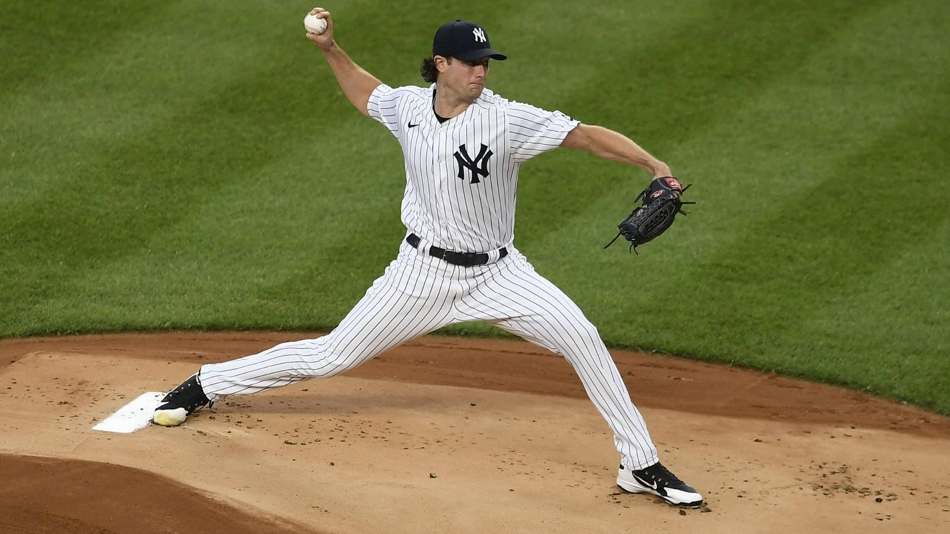 Gerrit Cole 桌布 壁紙 — 一名紐約洋基隊投手在陽光明媚的棒球投手丘上投球，身後是充滿活力的綠色草地。
