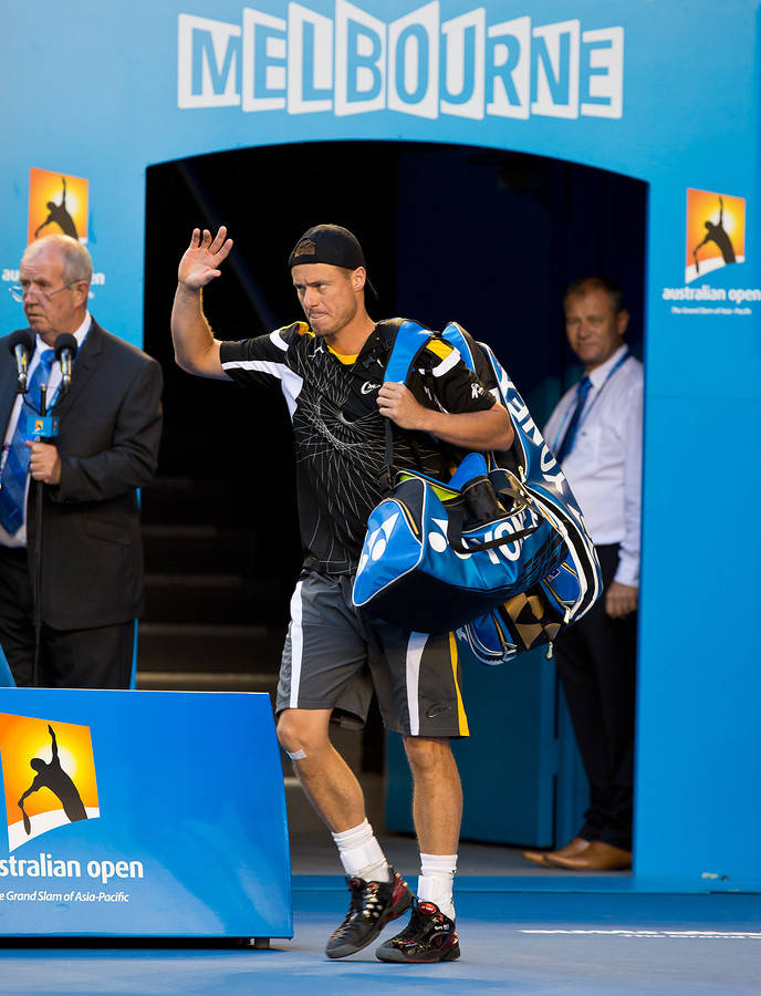 Australian Open 桌布 壁紙 — 一名網球選手背著藍色球拍袋離開墨爾本澳洲網球公開賽入口，向粉絲揮手。