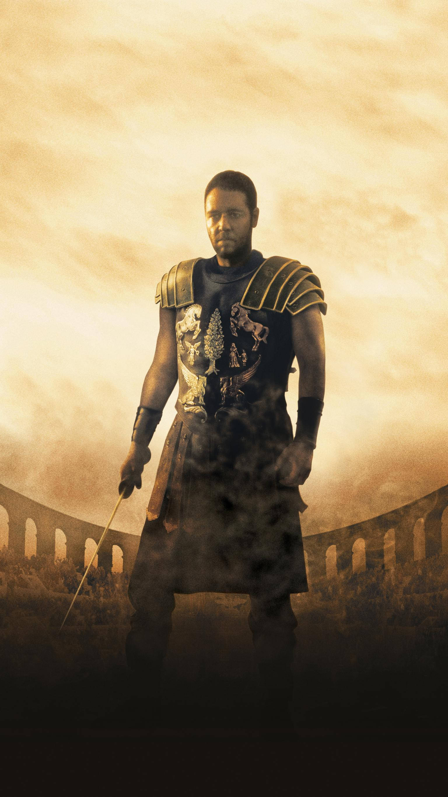 Gladiator 桌布 壁紙 — 一名羅馬士兵莊嚴地站在塵土飛揚的競技場中，在金色朦朧的天空下手持劍。
