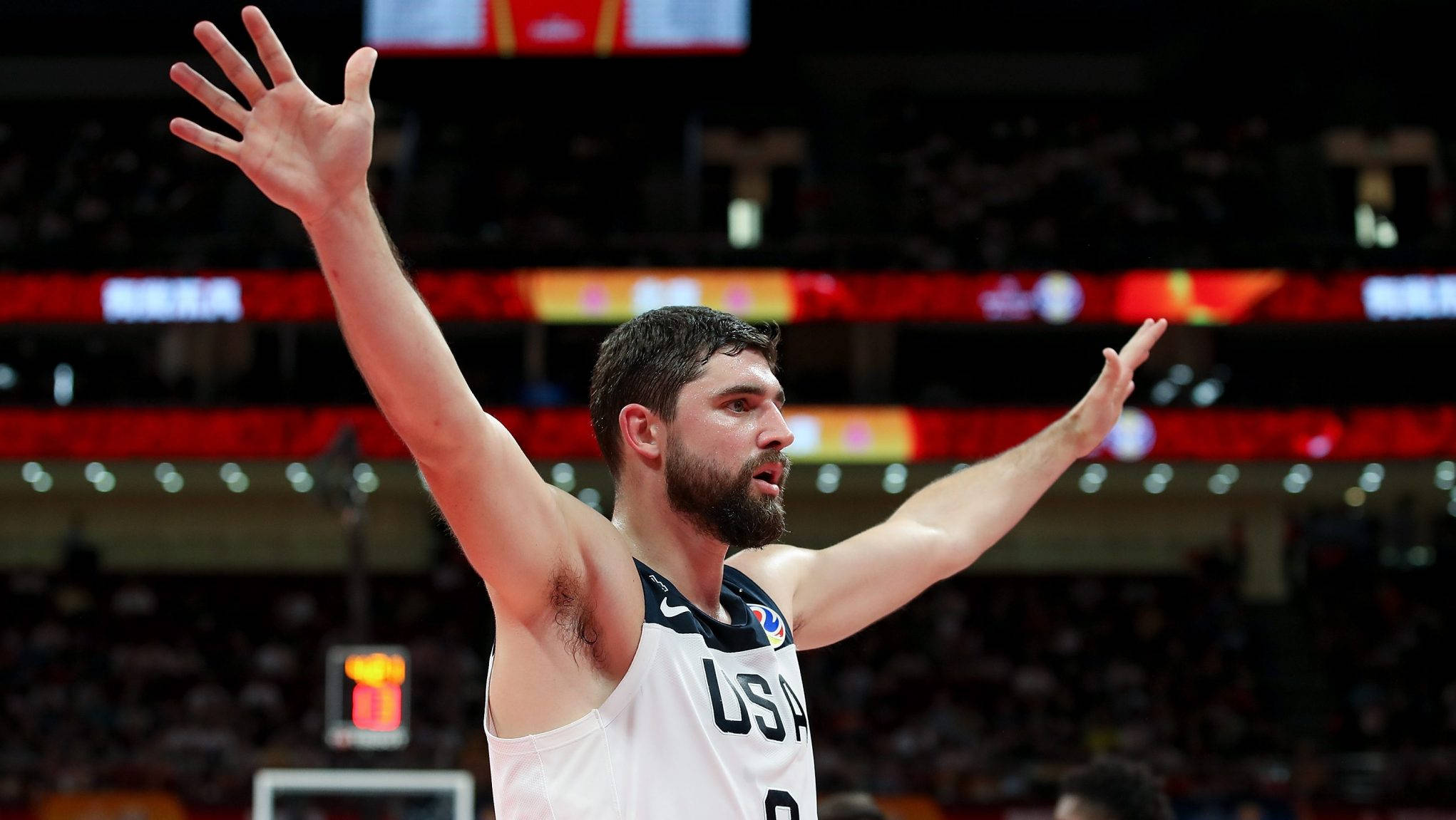 joe harris 桌布 壁紙 — 一名美國籃球運動員在燈光明亮的球場上高舉雙臂慶祝勝利，面前是歡呼的人群。