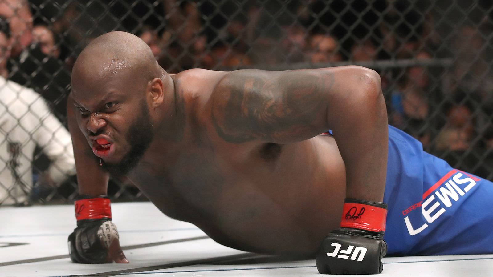 UFC 桌布 壁紙 — 一名肌肉發達、滿身刺青的拳手在UFC八角籠內用力撐起身體，表情猙獰。