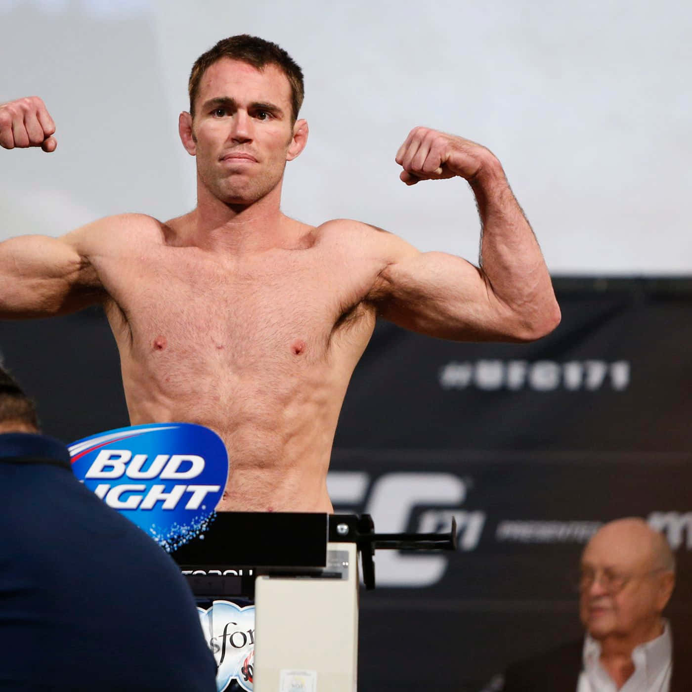MMA 桌布 壁紙 — 一名肌肉發達的男性拳手在UFC體重磅上彎曲手臂，可見Bud Light標誌。