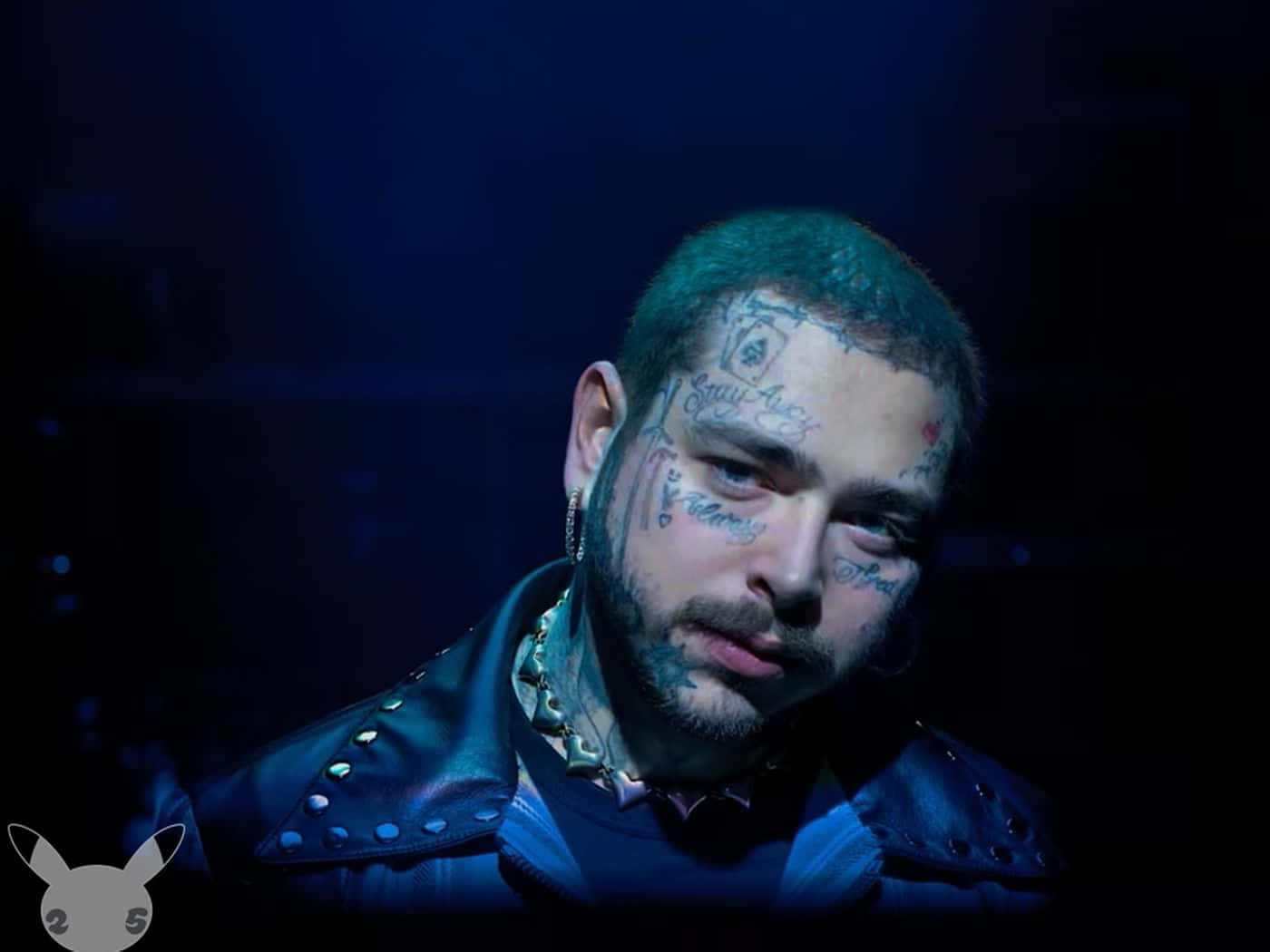 Post Malone 桌布 壁紙 — 一名臉上和頸部有刺青的男子，在藍色舞台燈光下穿著帶有鉚釘的皮夾克。