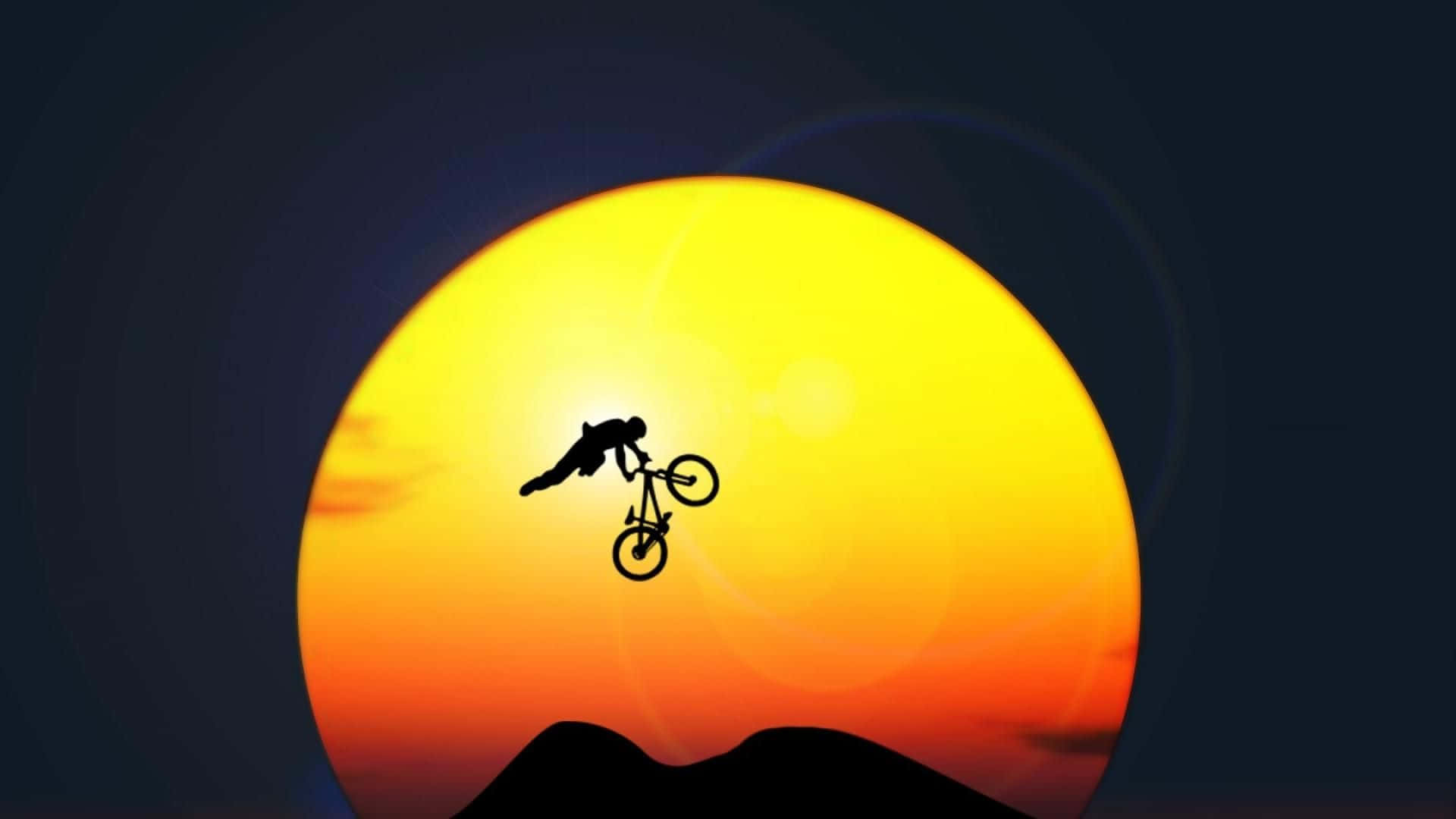 Mtb 桌布 壁紙 — 一名自行車手在山脈剪影上方巨大發光的日落背景下表演大膽的空中特技。