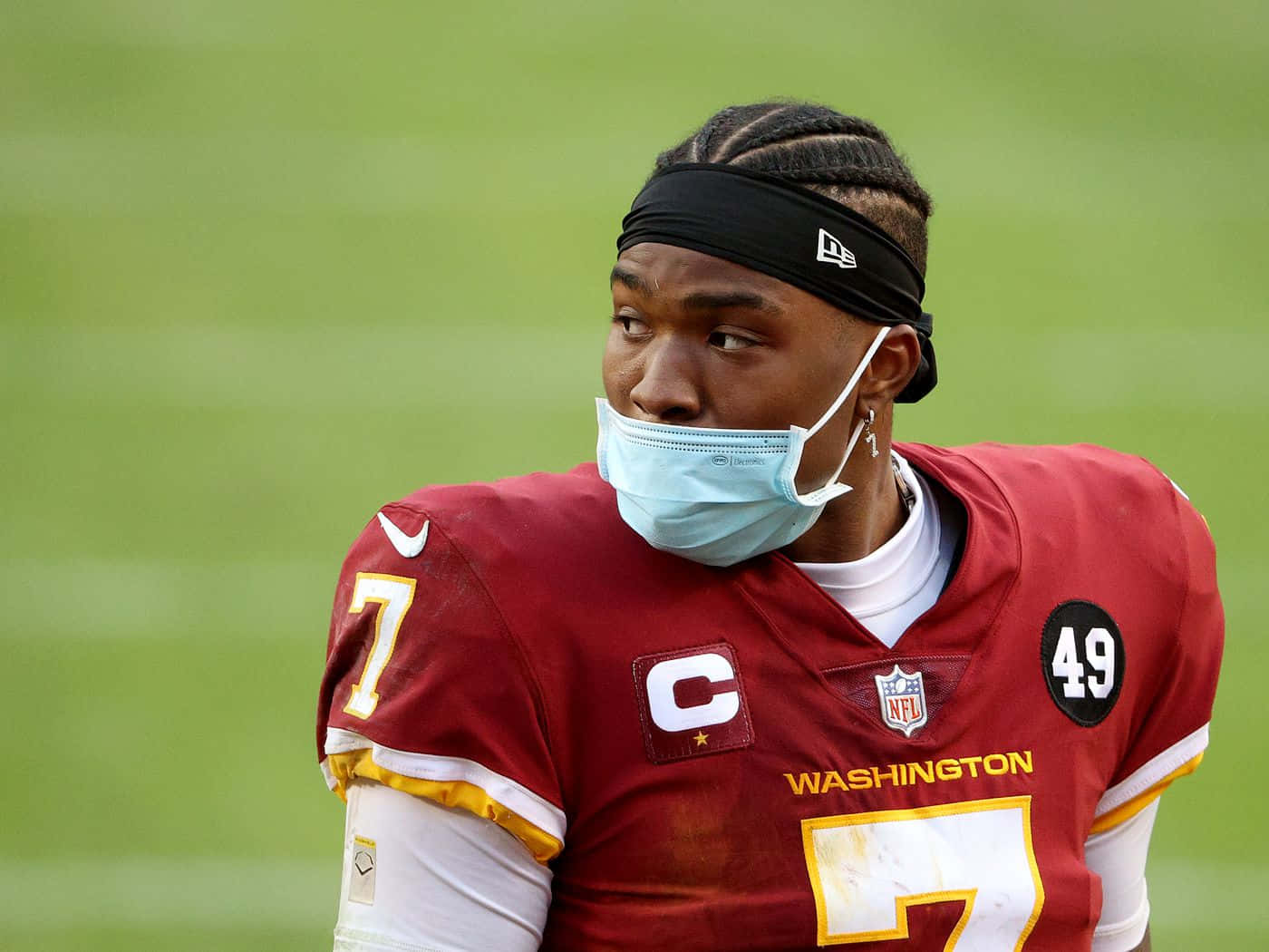 Dwayne Haskins 桌布 壁紙 — 一名華盛頓美式足球隊球員身穿紅色球衣及面罩，在綠色球場上望向一旁。
