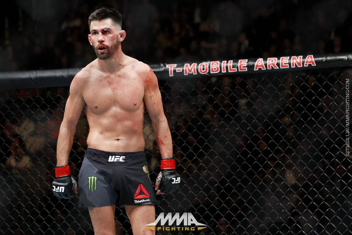 桌布 壁紙 — 一名血跡斑斑的MMA拳手在T-Mobile Arena的八角籠內，經過一場殘酷比賽後筋疲力盡地站立。