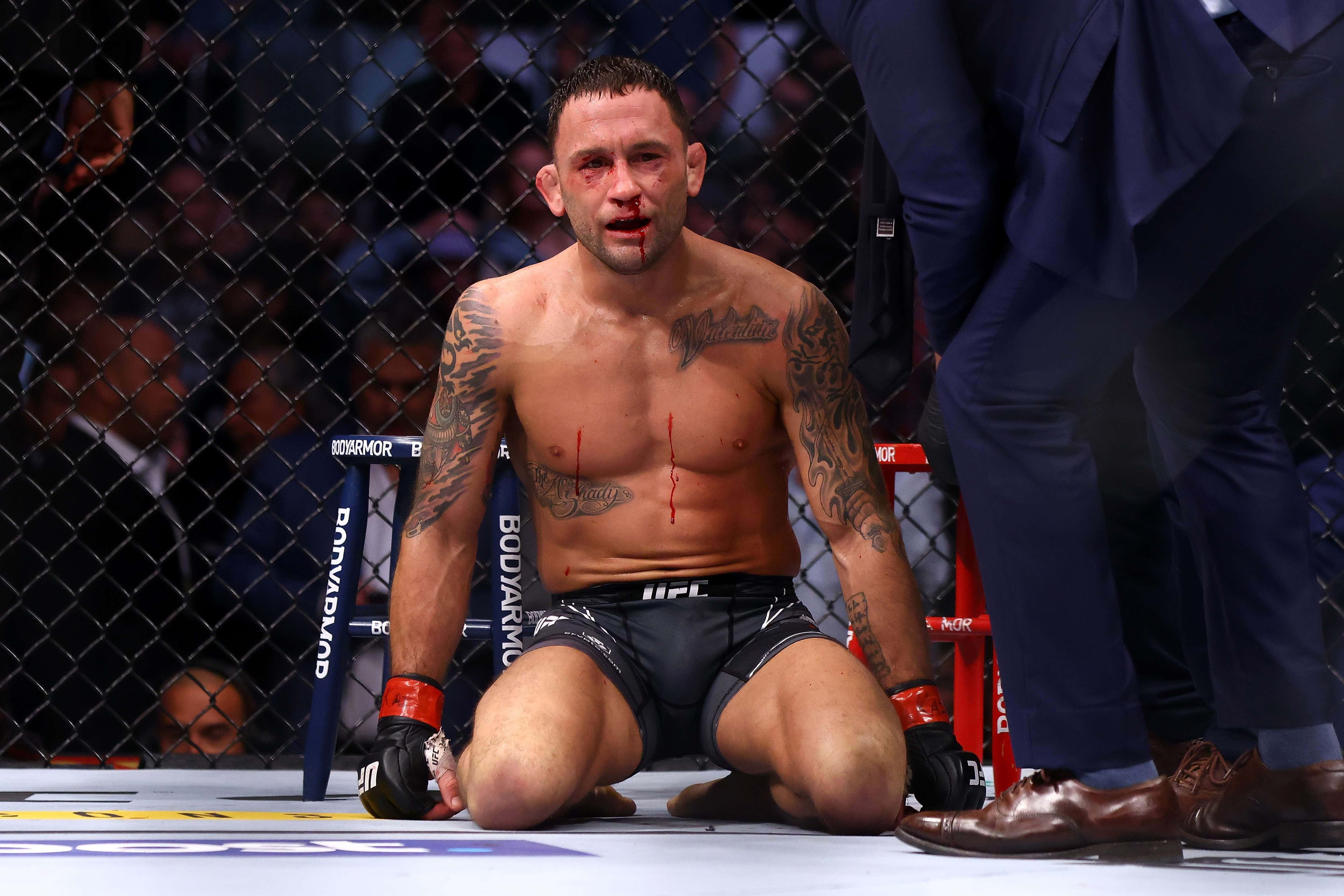 UFC 桌布 壁紙 — 一名血跡斑斑的MMA拳手在殘酷比賽後筋疲力盡地跪在UFC八角籠內。
