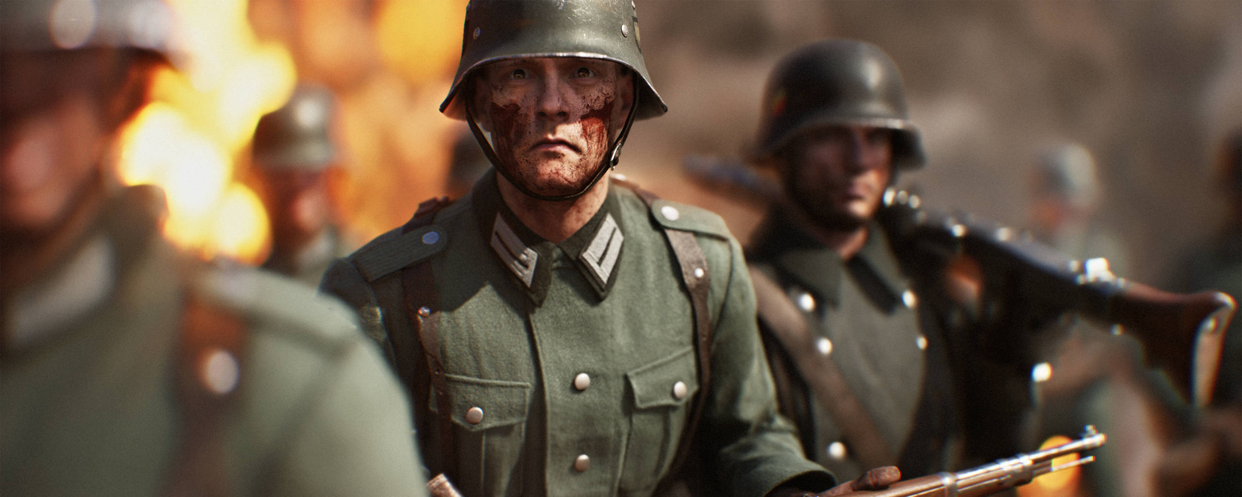 軍隊 桌布 壁紙 — 一名血跡斑斑的德國士兵穿著二戰軍服，在熾熱的戰場混亂中專注地向前凝視。