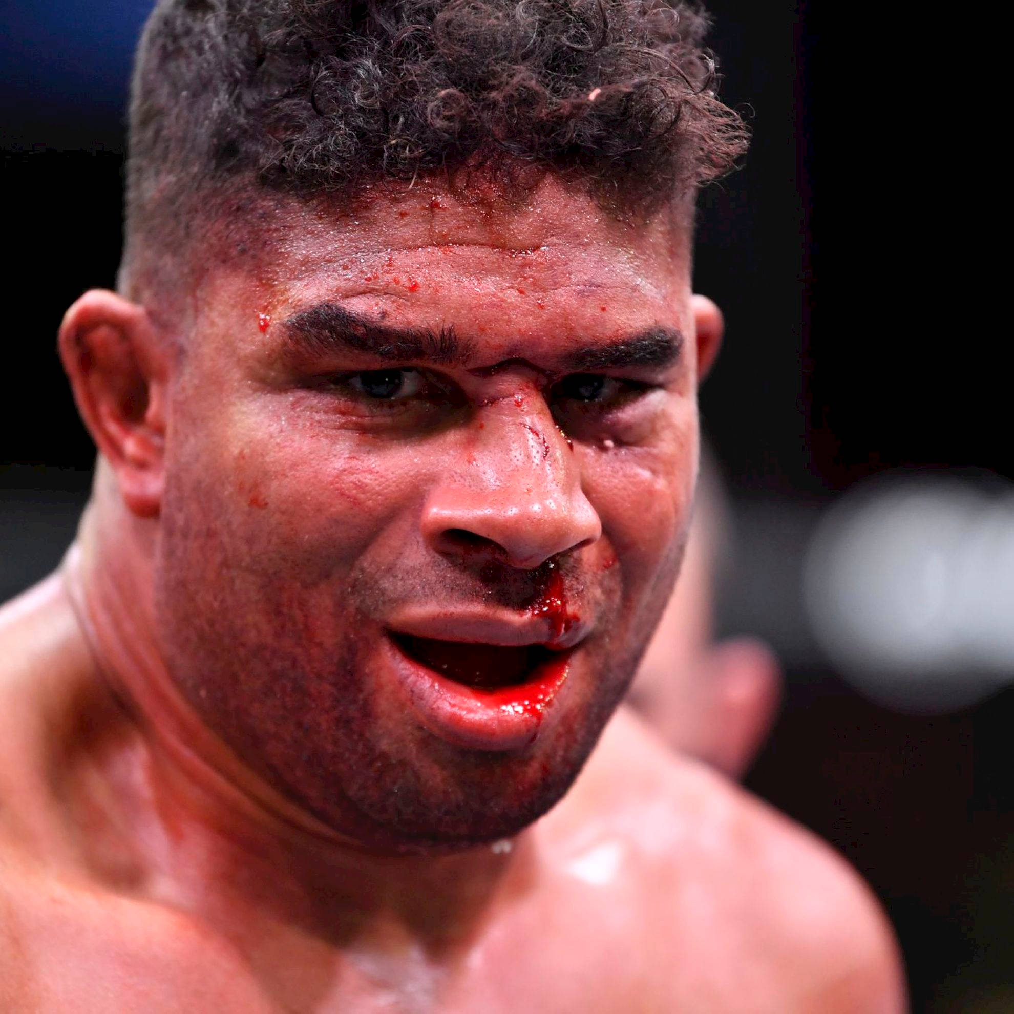 UFC 桌布 壁紙 — 一名血跡斑斑的戰士，在殘酷的MMA比賽中，眼神銳利，汗水在臉上閃閃發光。