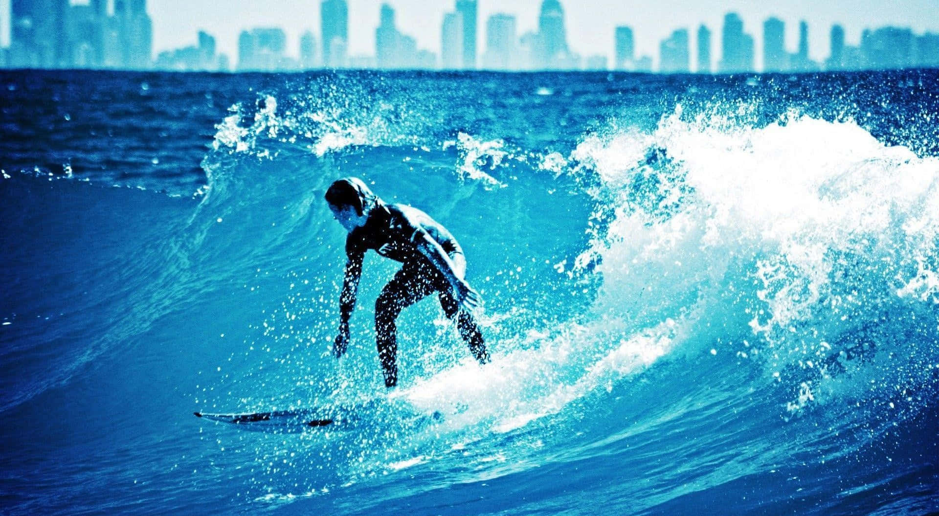 surfing 桌布 壁紙 — 一名衝浪者在明亮的日光下乘著強勁的藍色海浪，遠處可見城市天際線。