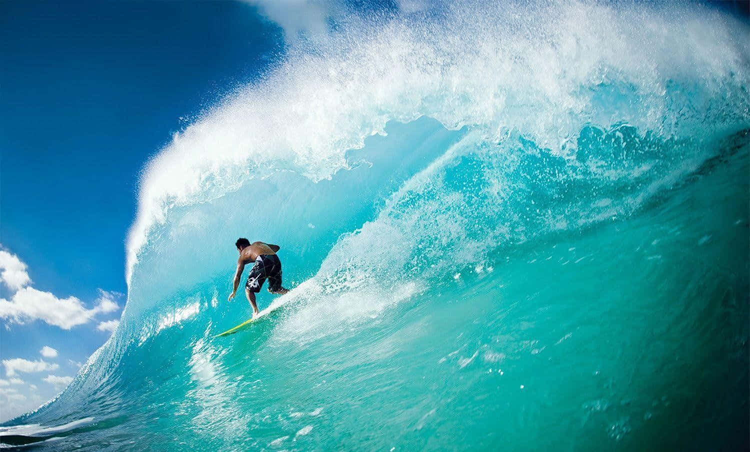 surfing 桌布 壁紙 — 一名衝浪者在晴朗的藍天下駕馭著巨大的碧綠色海浪，周圍白色泡沫四濺。
