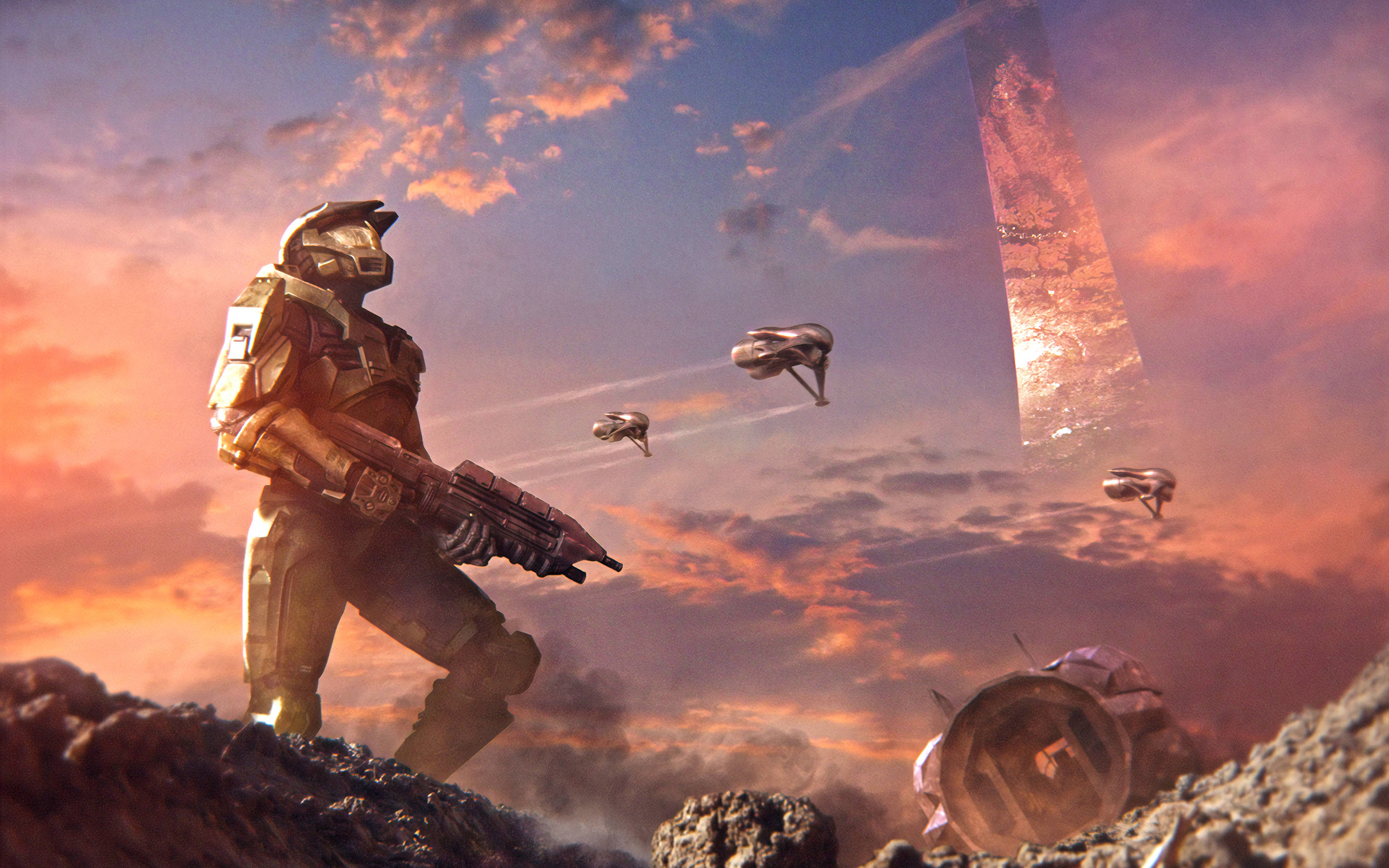 Master Chief 桌布 壁紙 — 一名裝甲士兵站在岩石外星行星上，夕陽下戰鬥機飛過高聳發光的巨石。
