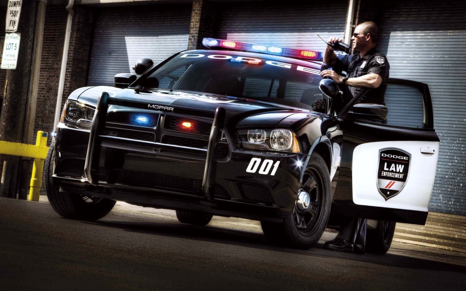 一名警察站在警車旁 壁紙