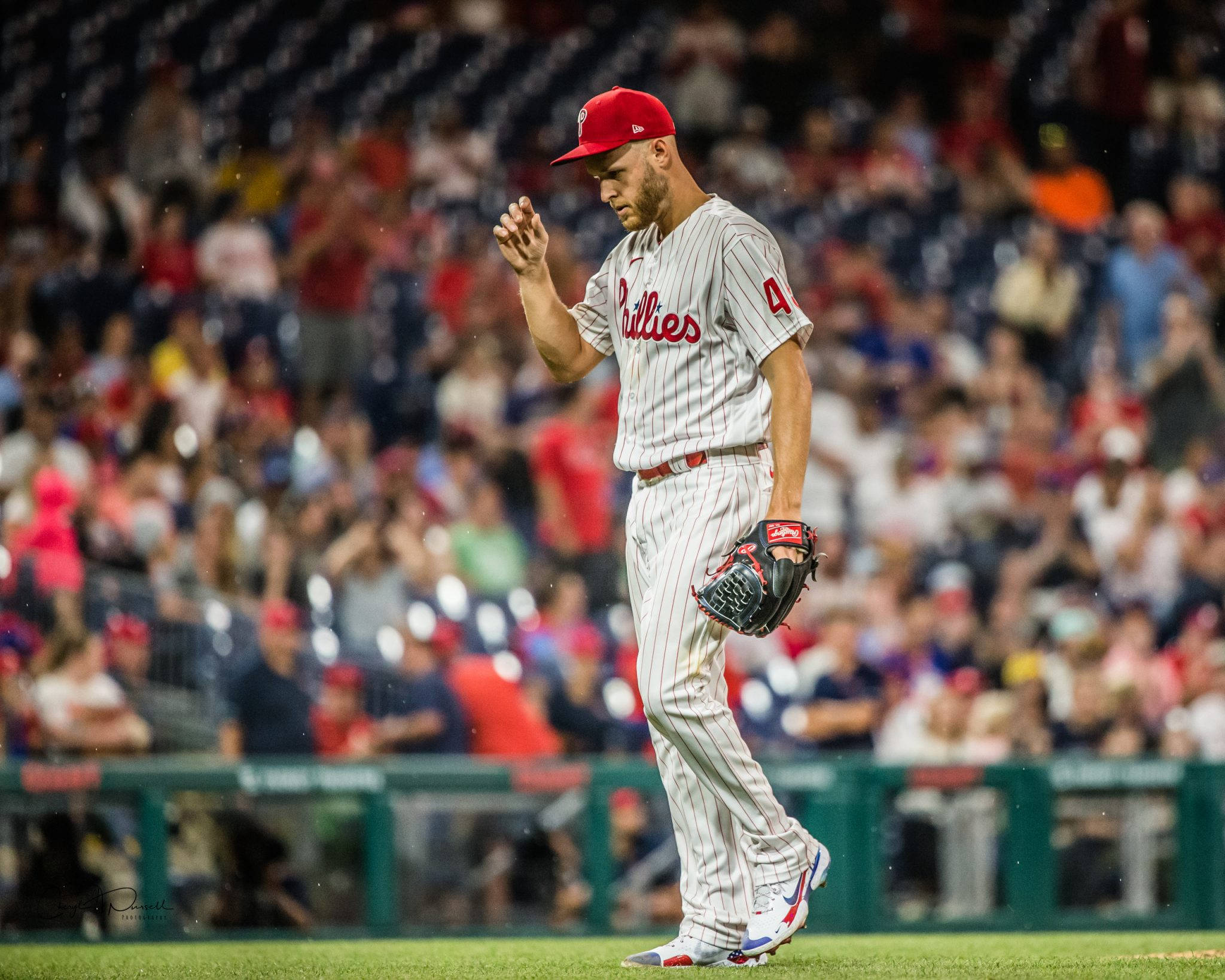Phillies 桌布 壁紙 — 一名費城費城人棒球運動員在夜晚球場燈光下帶著失望的表情離場。