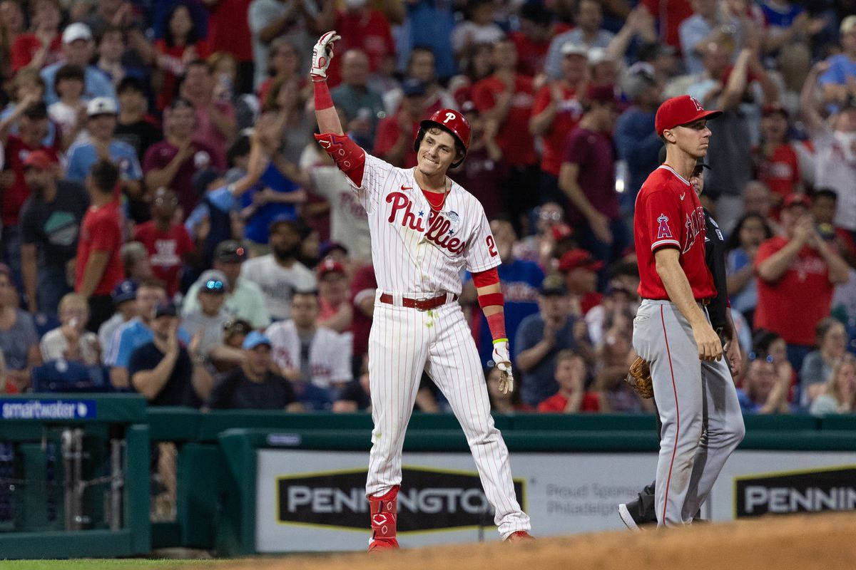 Phillies 桌布 壁紙 — 一名費城費城人隊的棒球運動員穿著白色細條紋制服，在夜間比賽中向歡呼的球迷揮手。