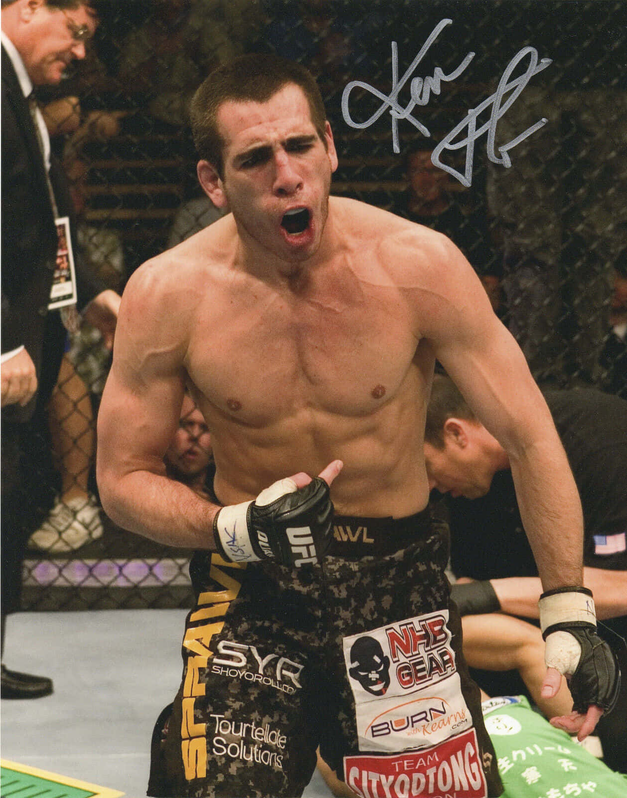 UFC 桌布 壁紙 — 一名赤裸上身的MMA拳手在八角籠中勝利後，展示簽名並發出勝利的咆哮。